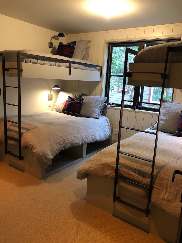 A bedroom with three bunk beds and a window.