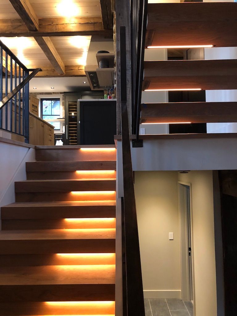 A wooden staircase with lights on the steps