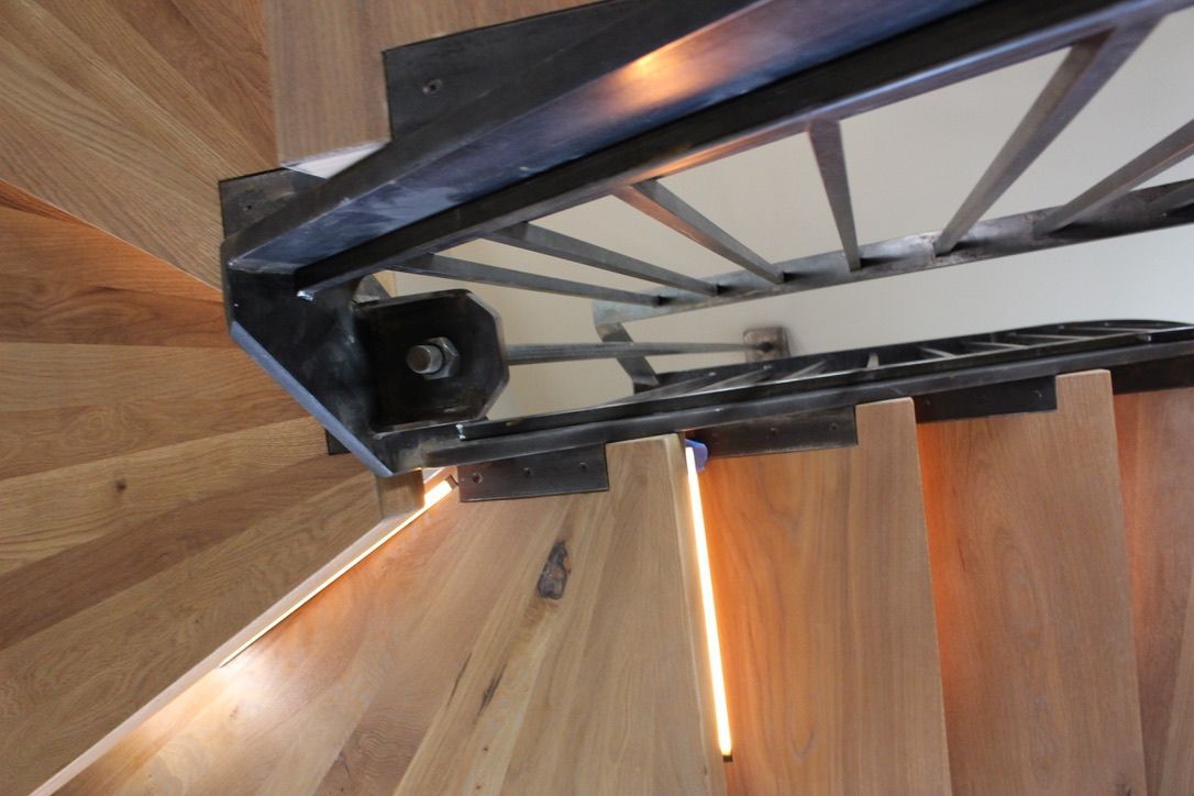 A spiral staircase with wooden steps and a metal railing