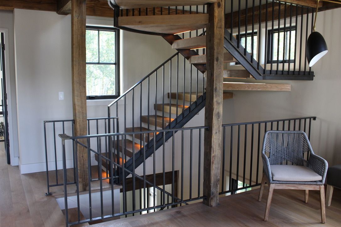 A wooden staircase with a metal railing in a house