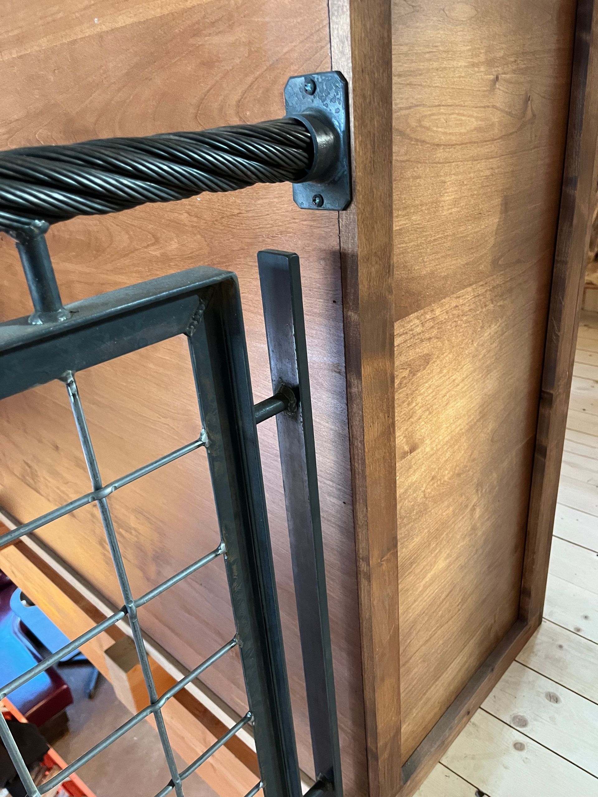 A close up of a metal railing on a wooden wall