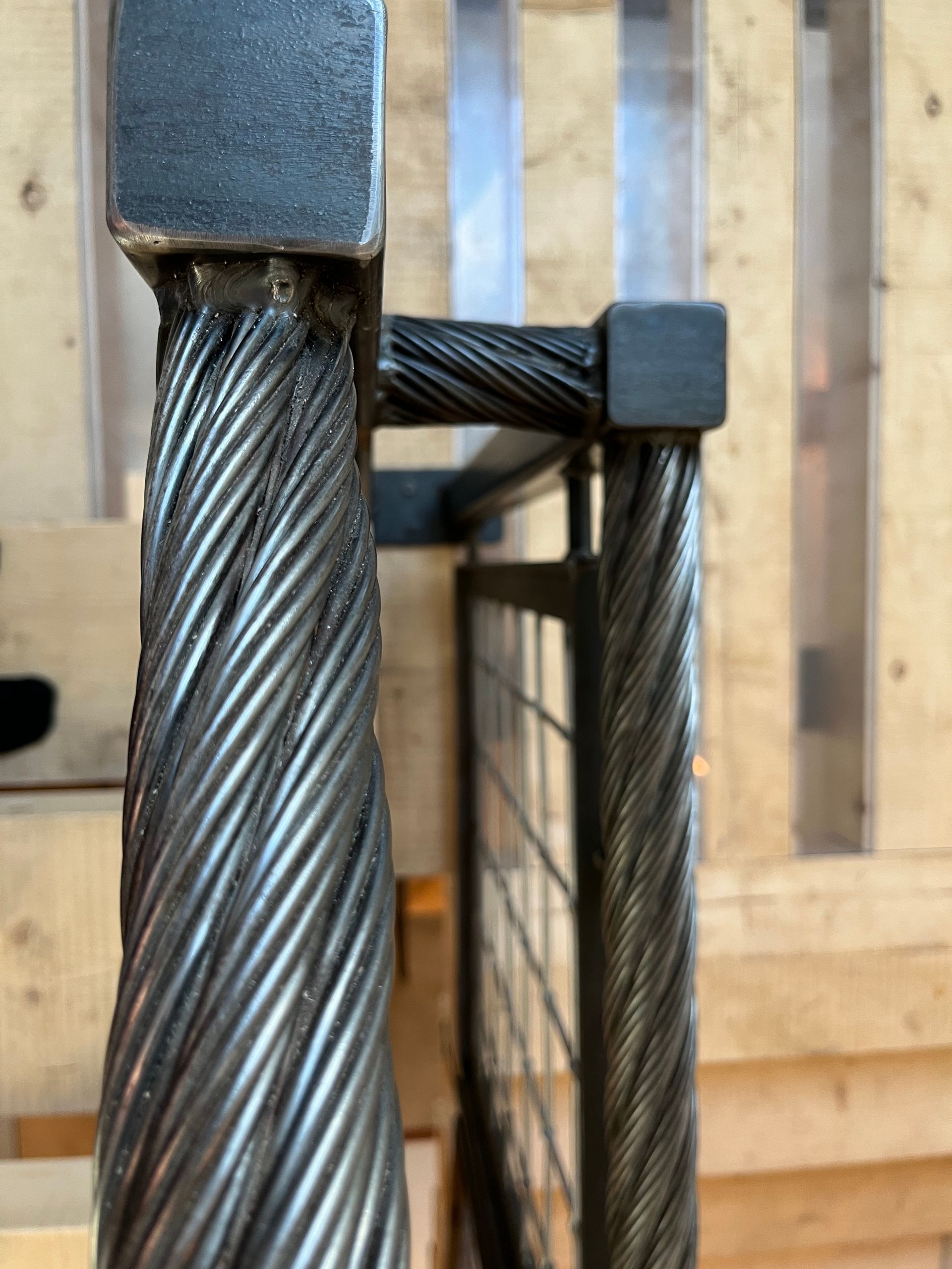 A close up of a metal railing on a wooden staircase.