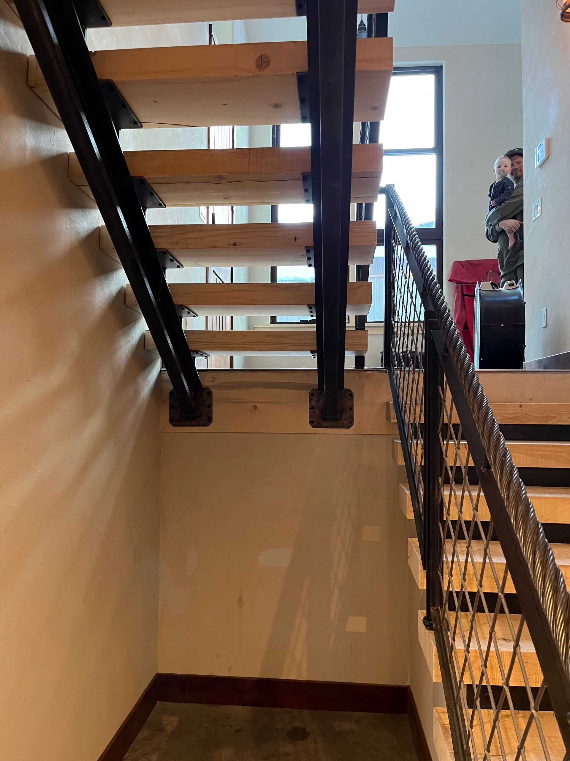 A wooden staircase with a metal railing in a house.