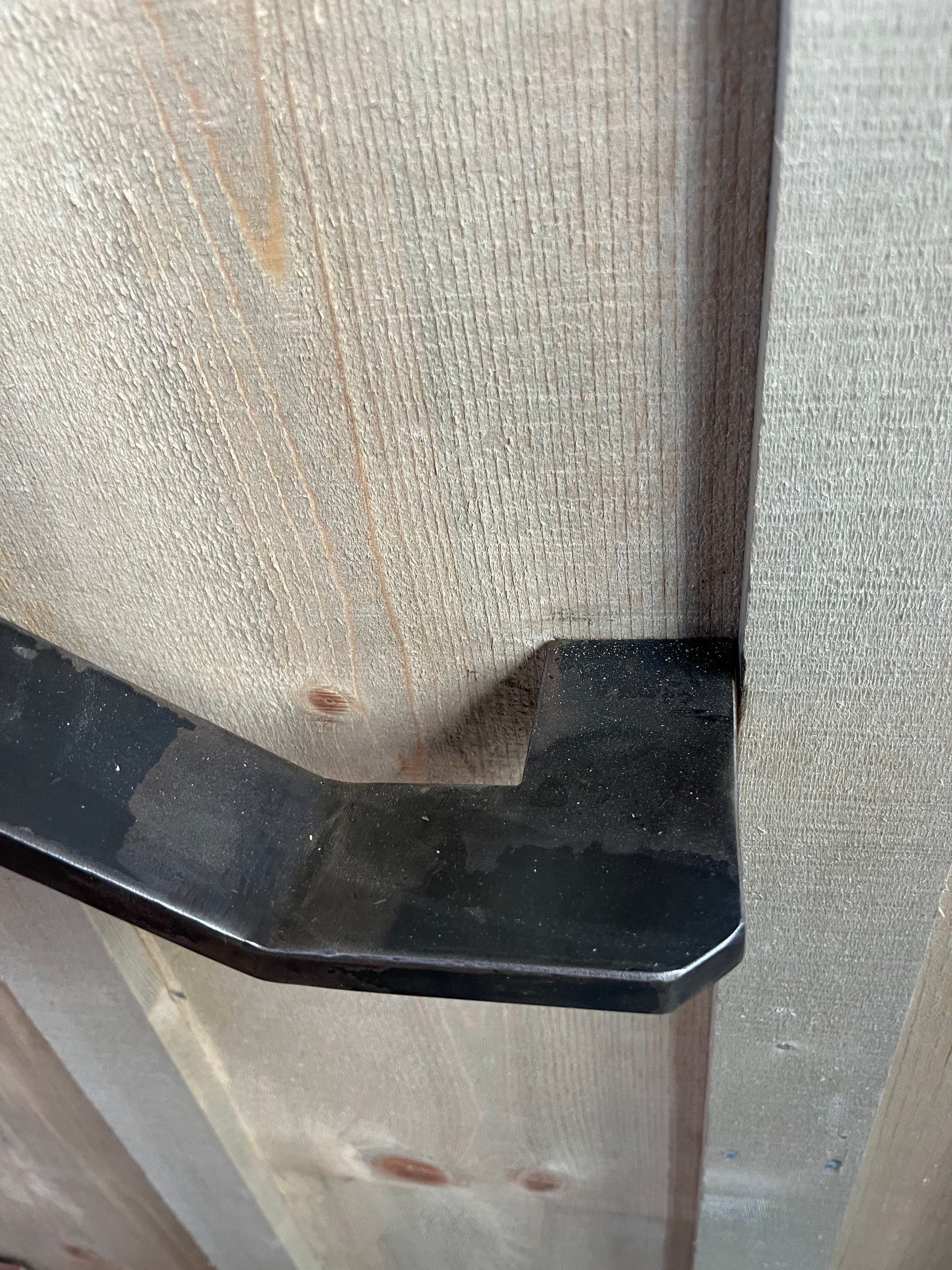 A close up of a piece of wood with a metal handle on it.