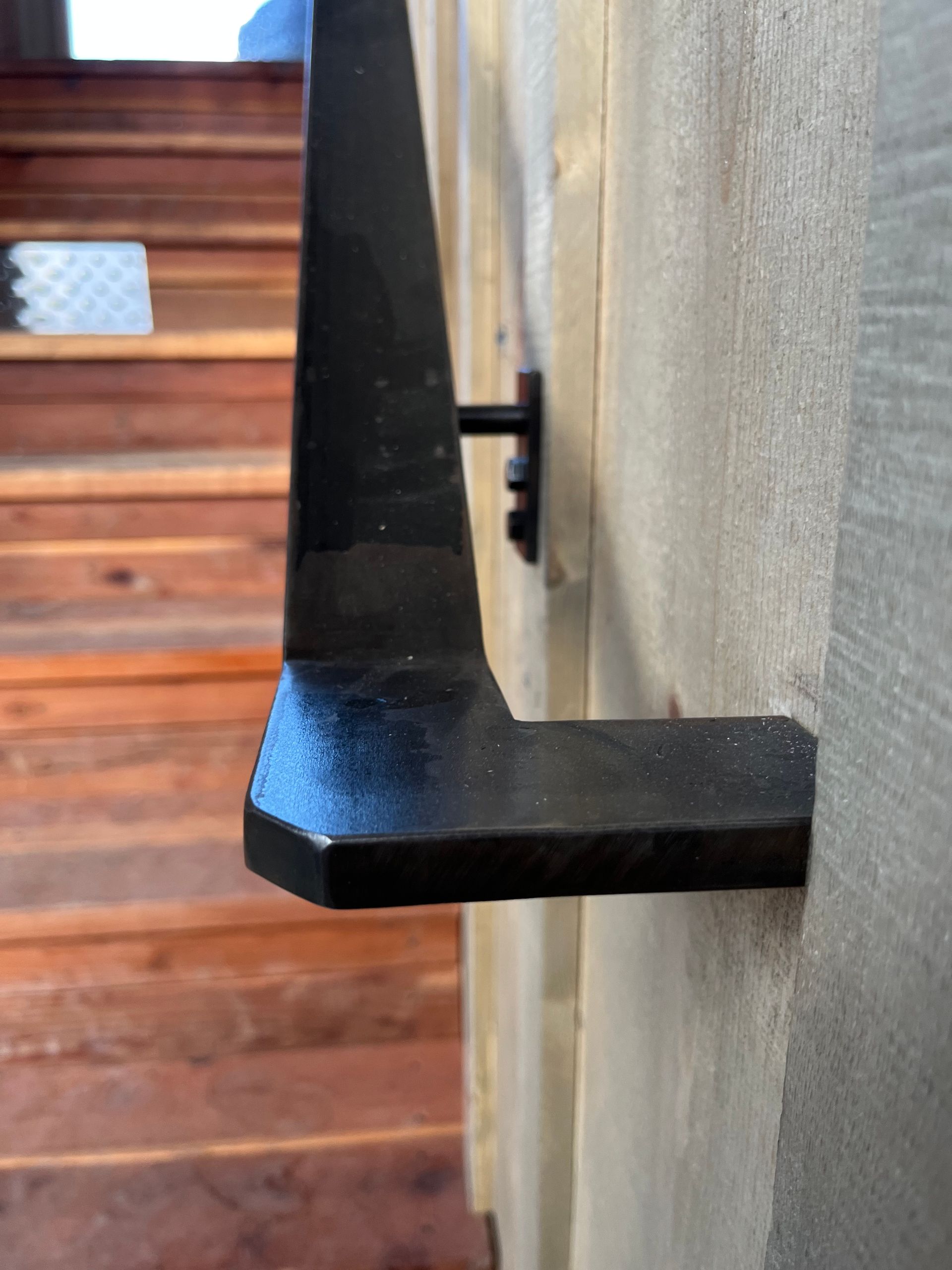 A close up of a railing on a wall next to stairs.