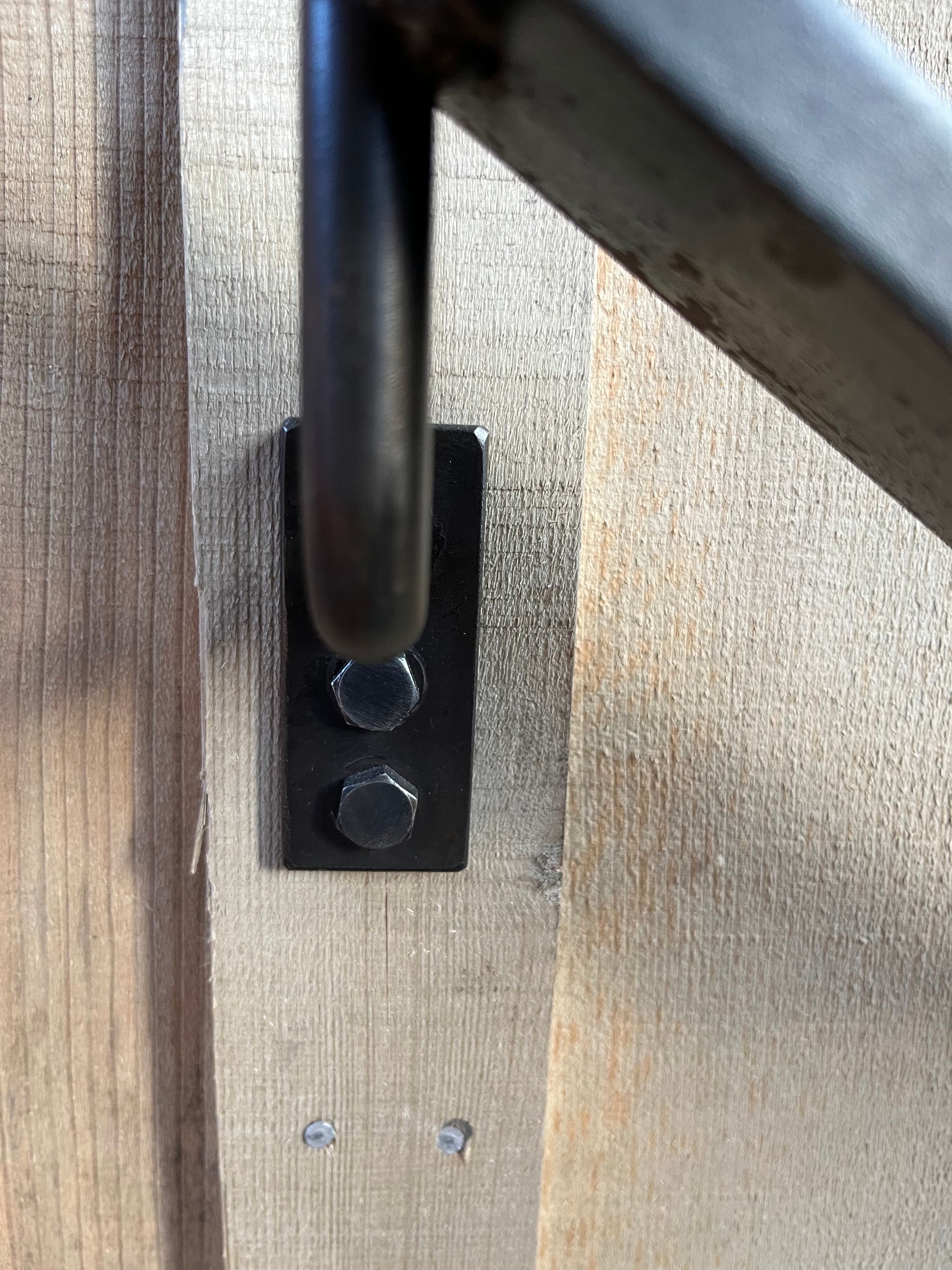 A metal railing is attached to a wooden wall.