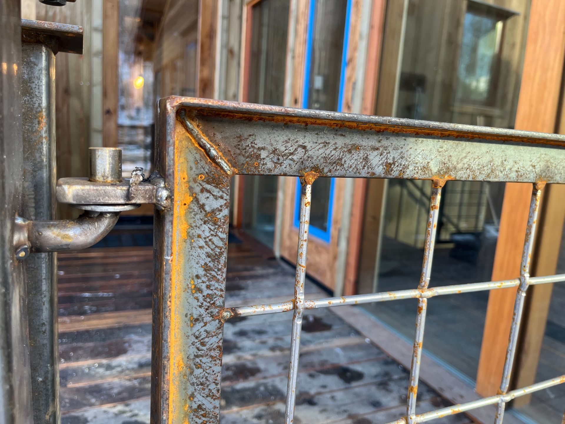 A close up of a rusty metal fence in front of a building