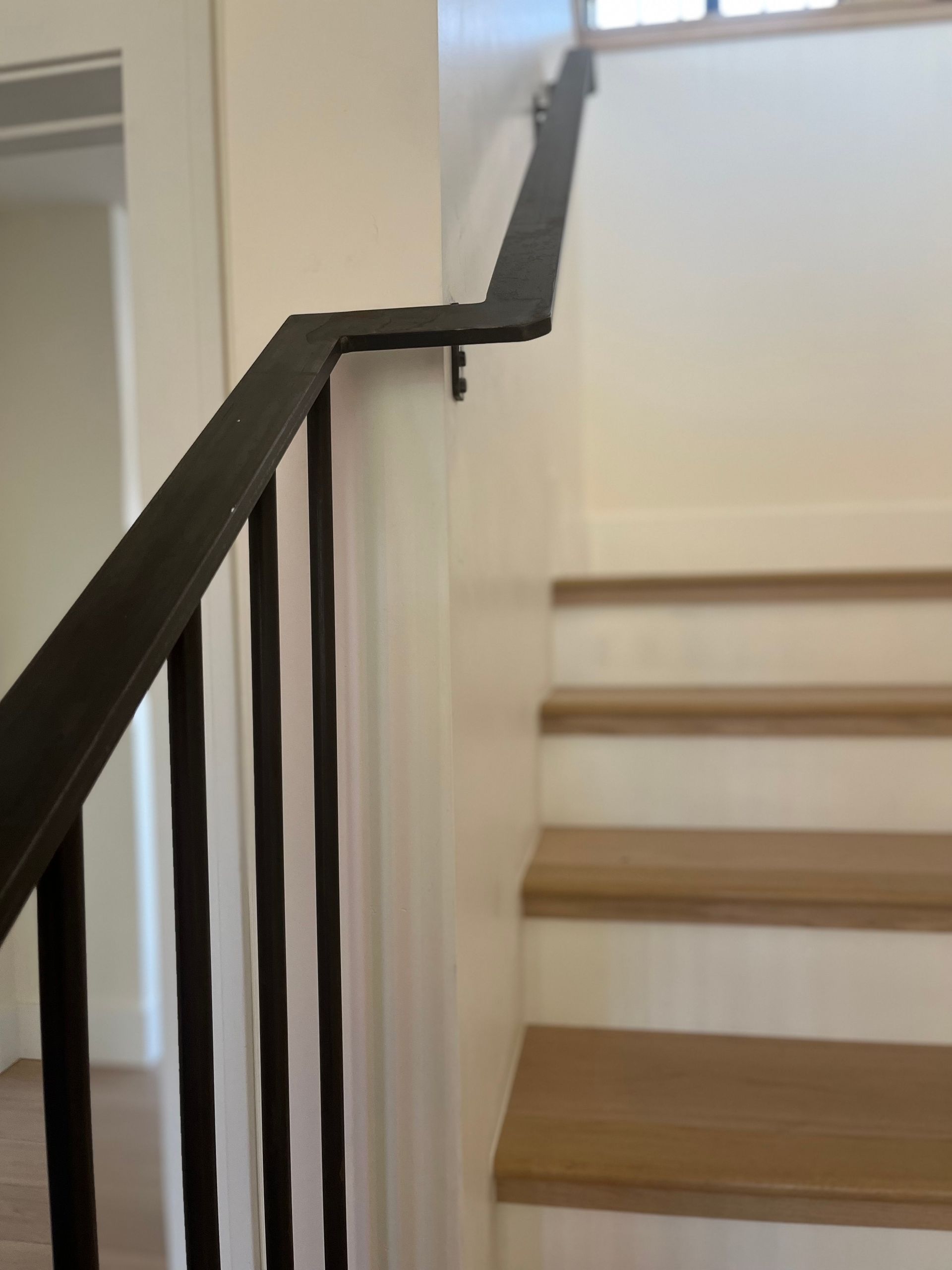 A staircase with a black railing and wooden steps