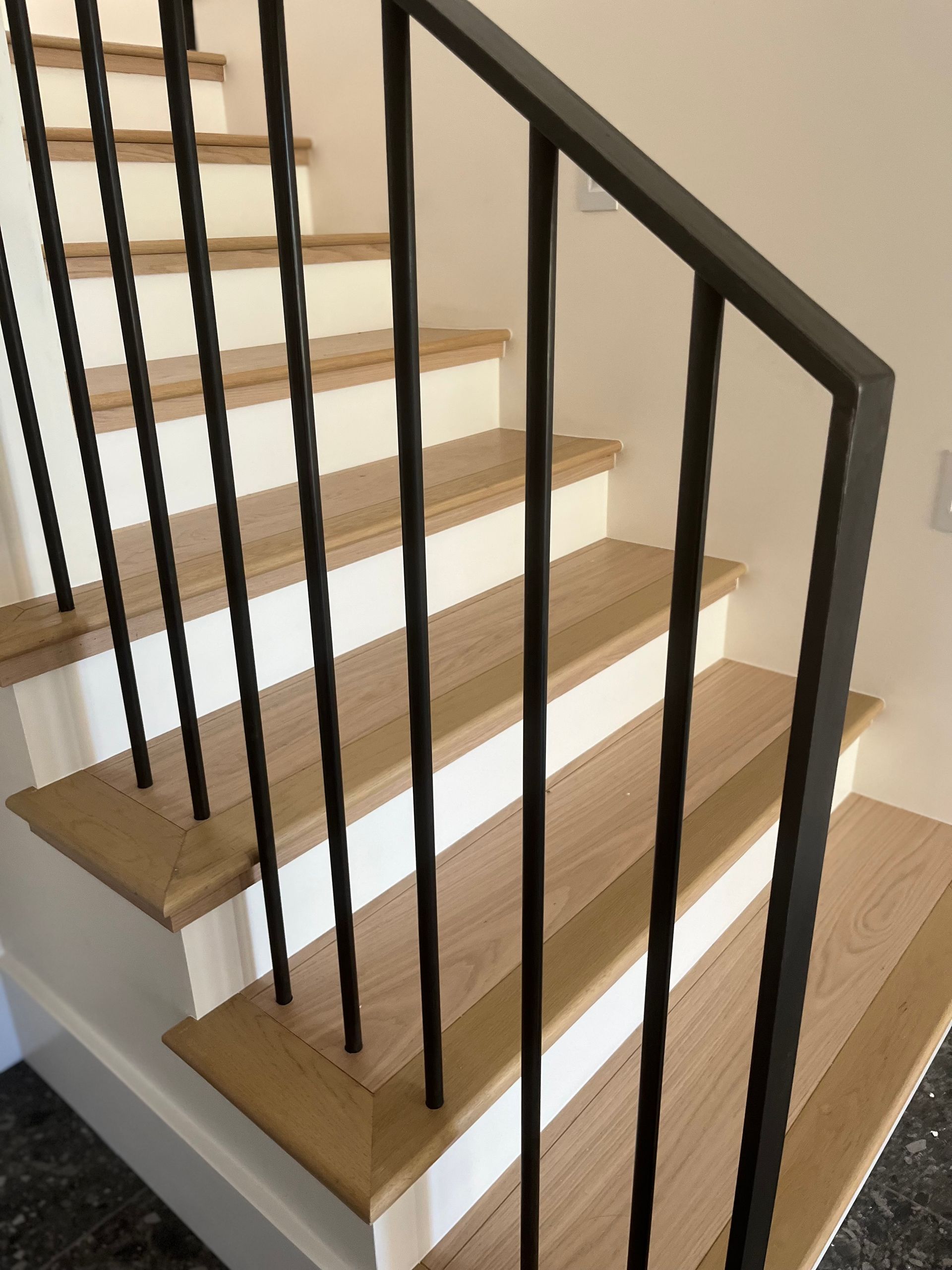 A staircase with wooden steps and a black railing