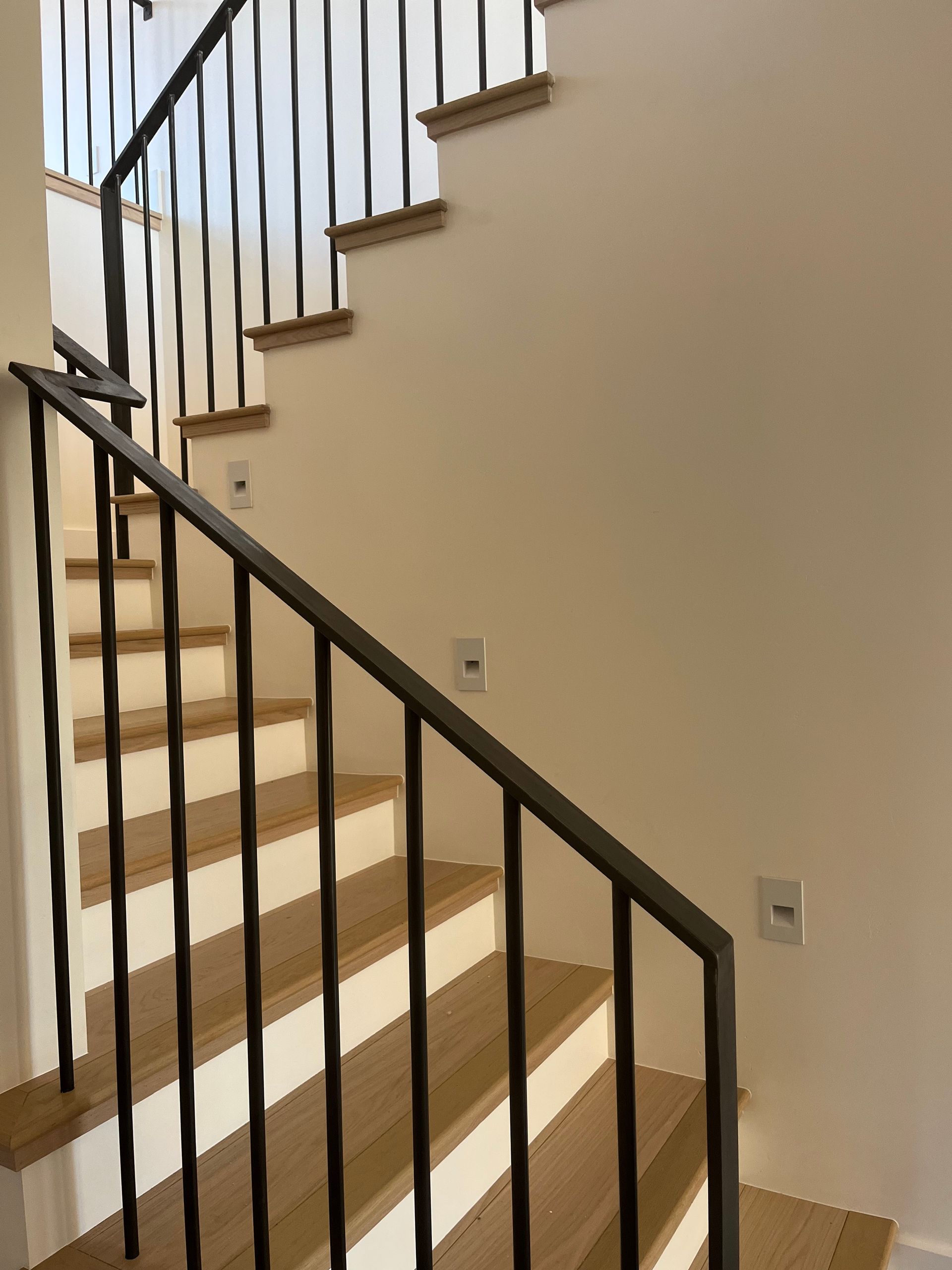 A staircase with a wrought iron railing and wooden steps