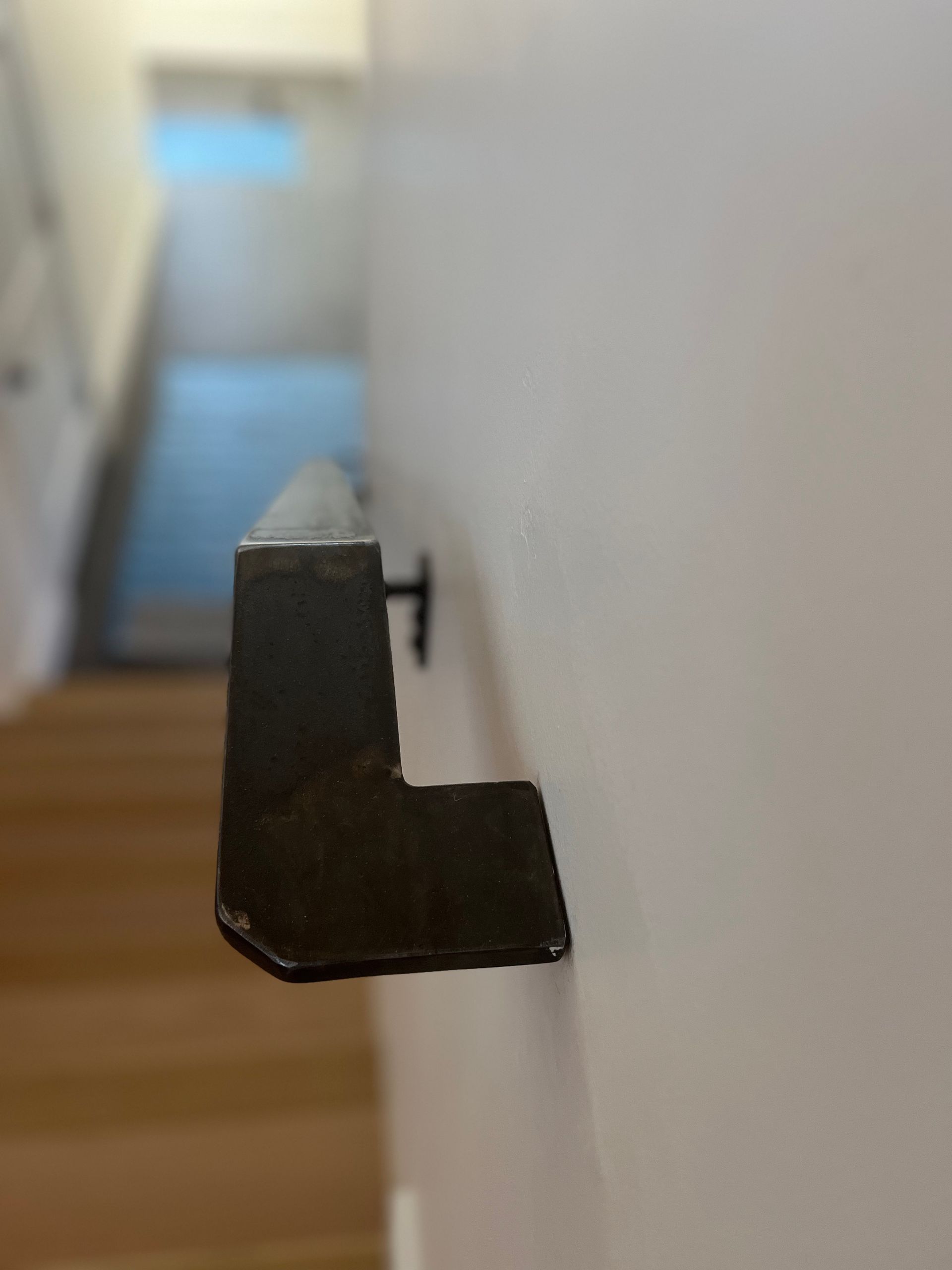 A close up of a railing on a wall next to a staircase.