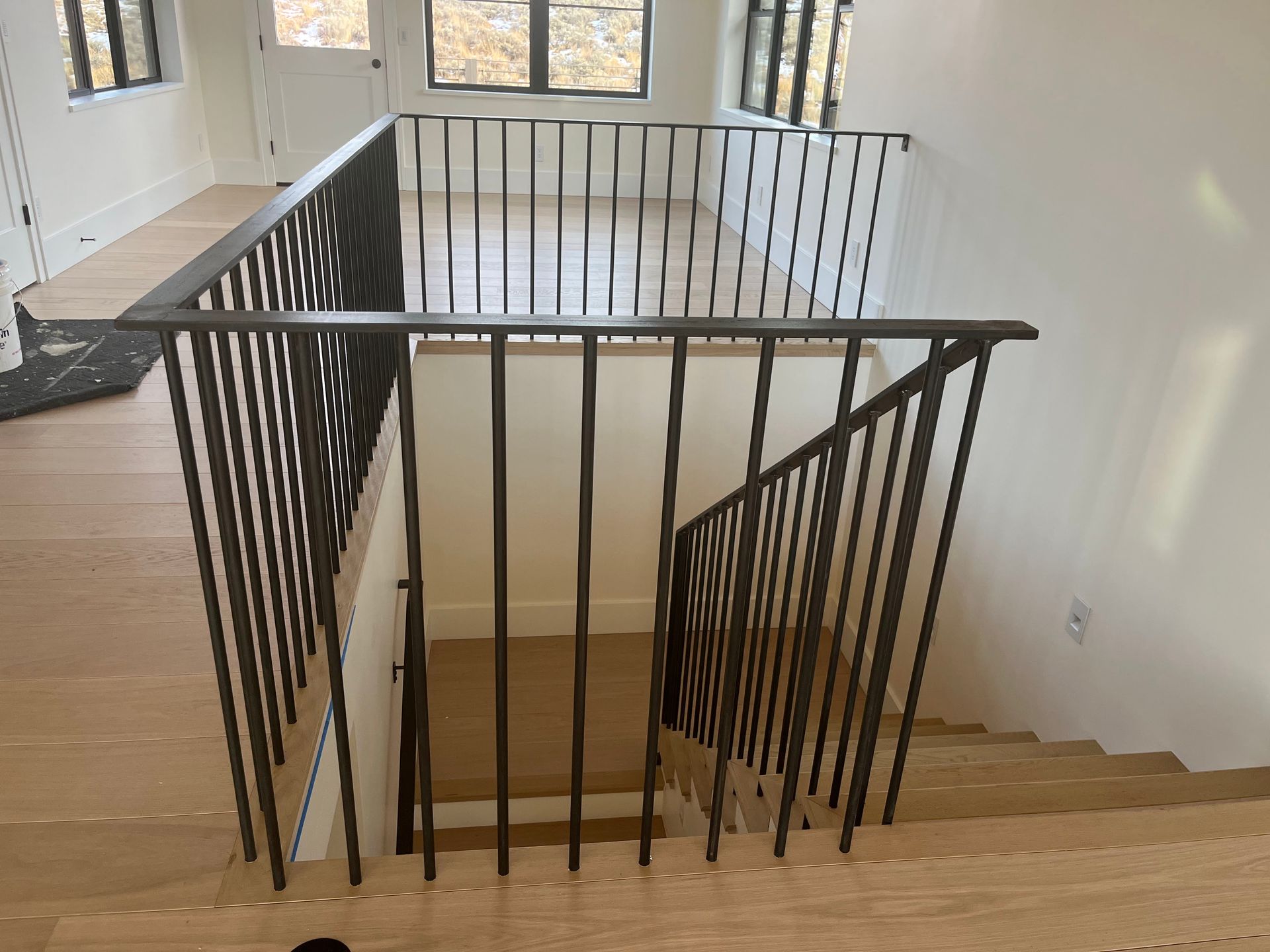 A staircase with a metal railing and wooden steps in a house.