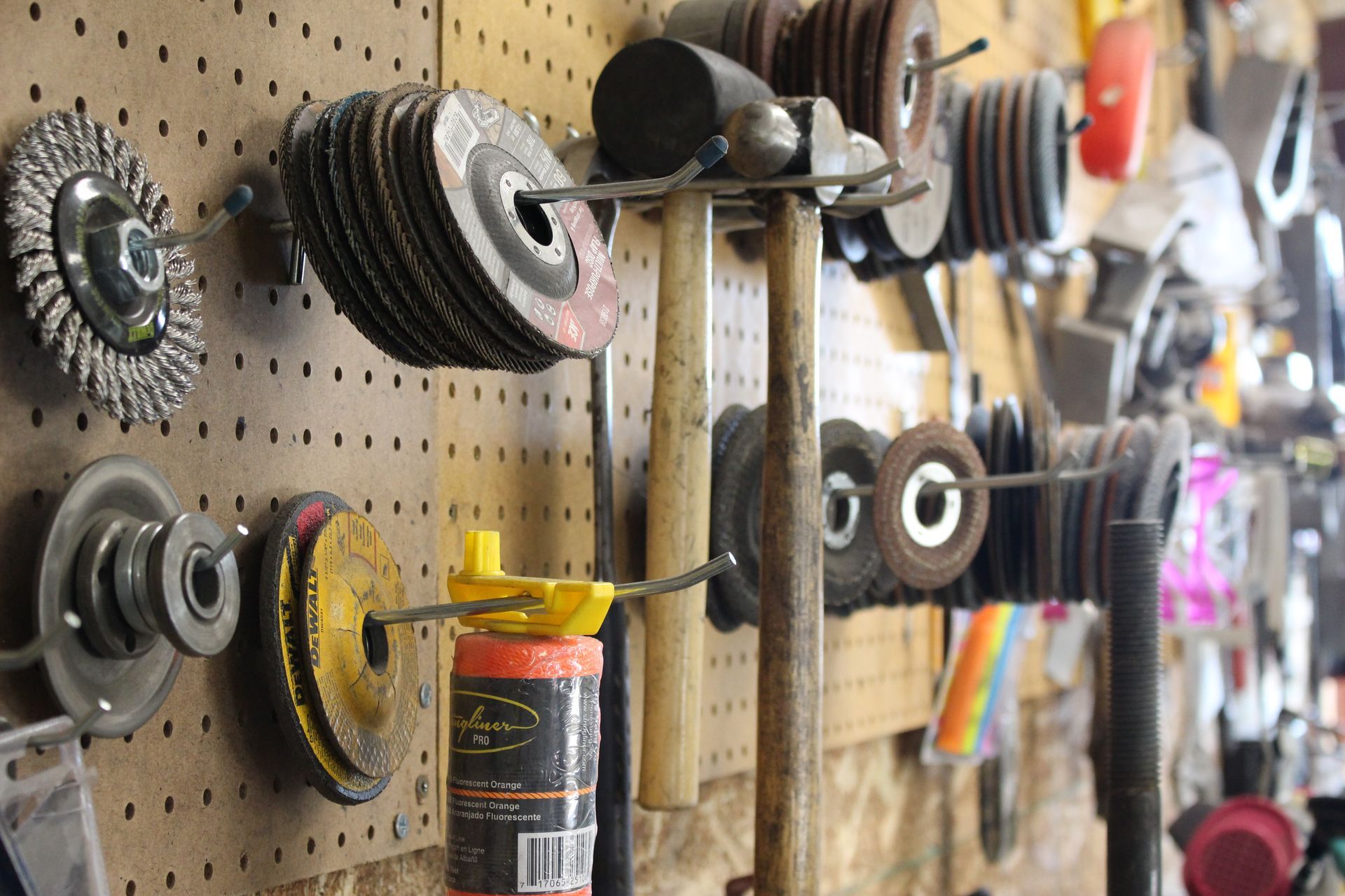 A bunch of tools hanging on a wall including a hammer