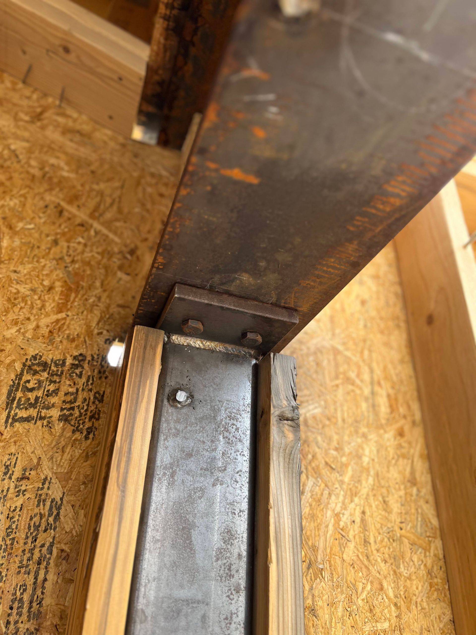 A close up of a metal beam sitting on top of a wooden frame.