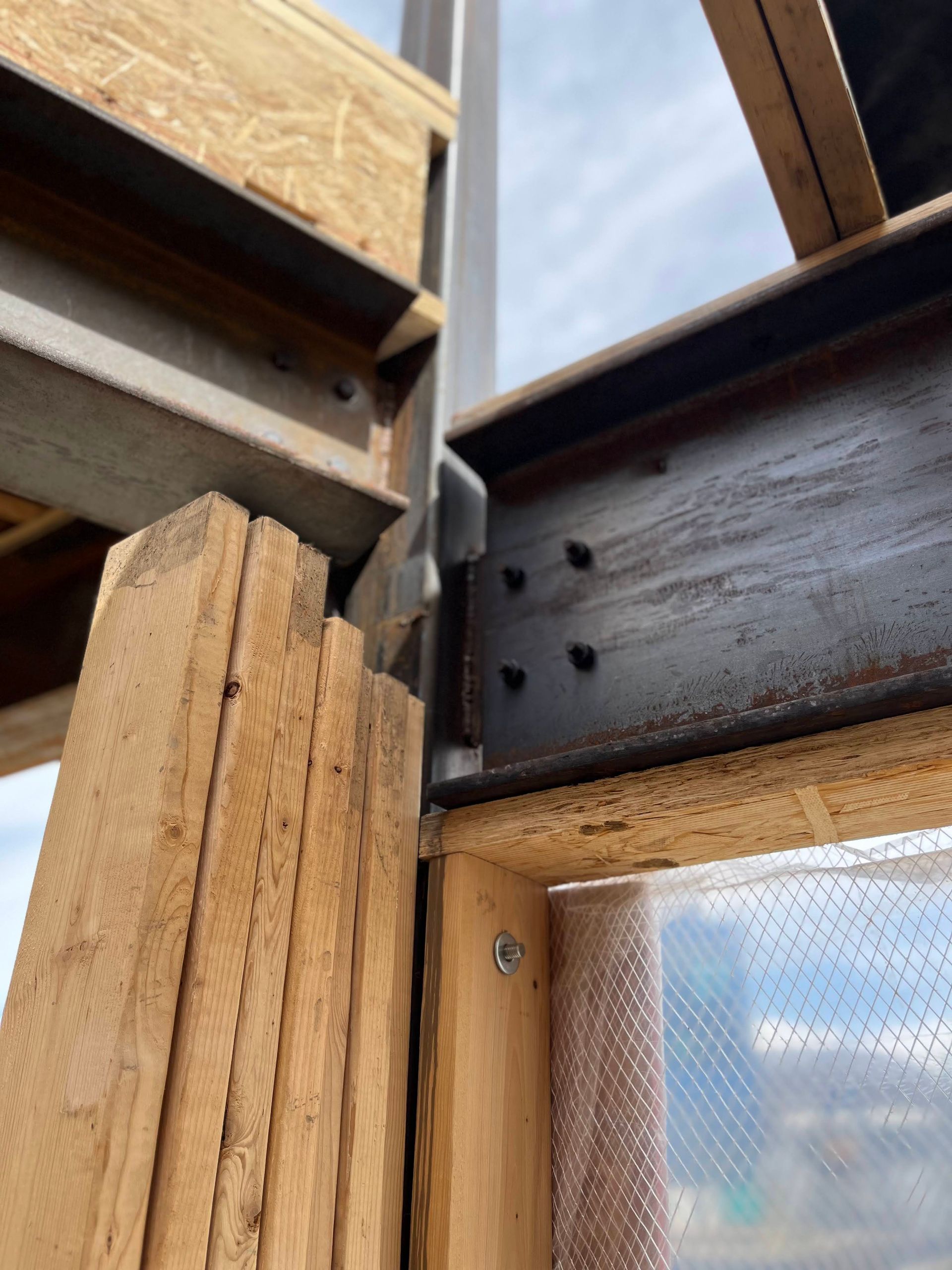 A close up of a wooden structure with a metal beam
