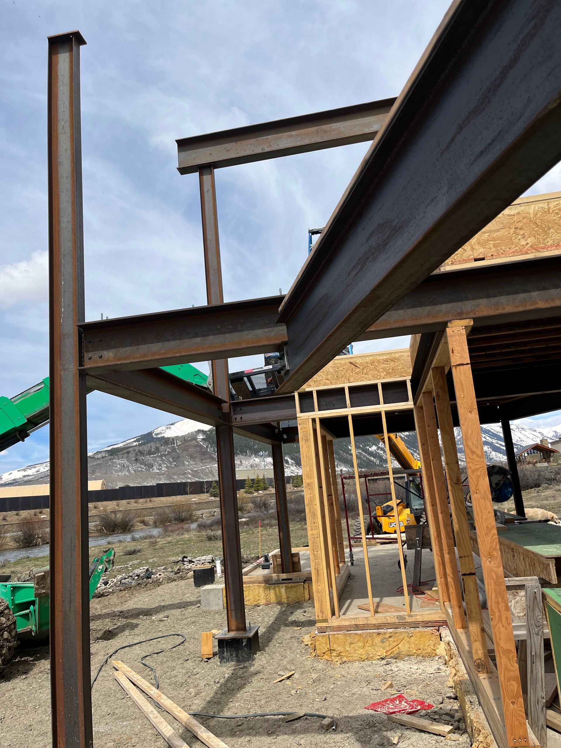 A building under construction with a green crane in the background.