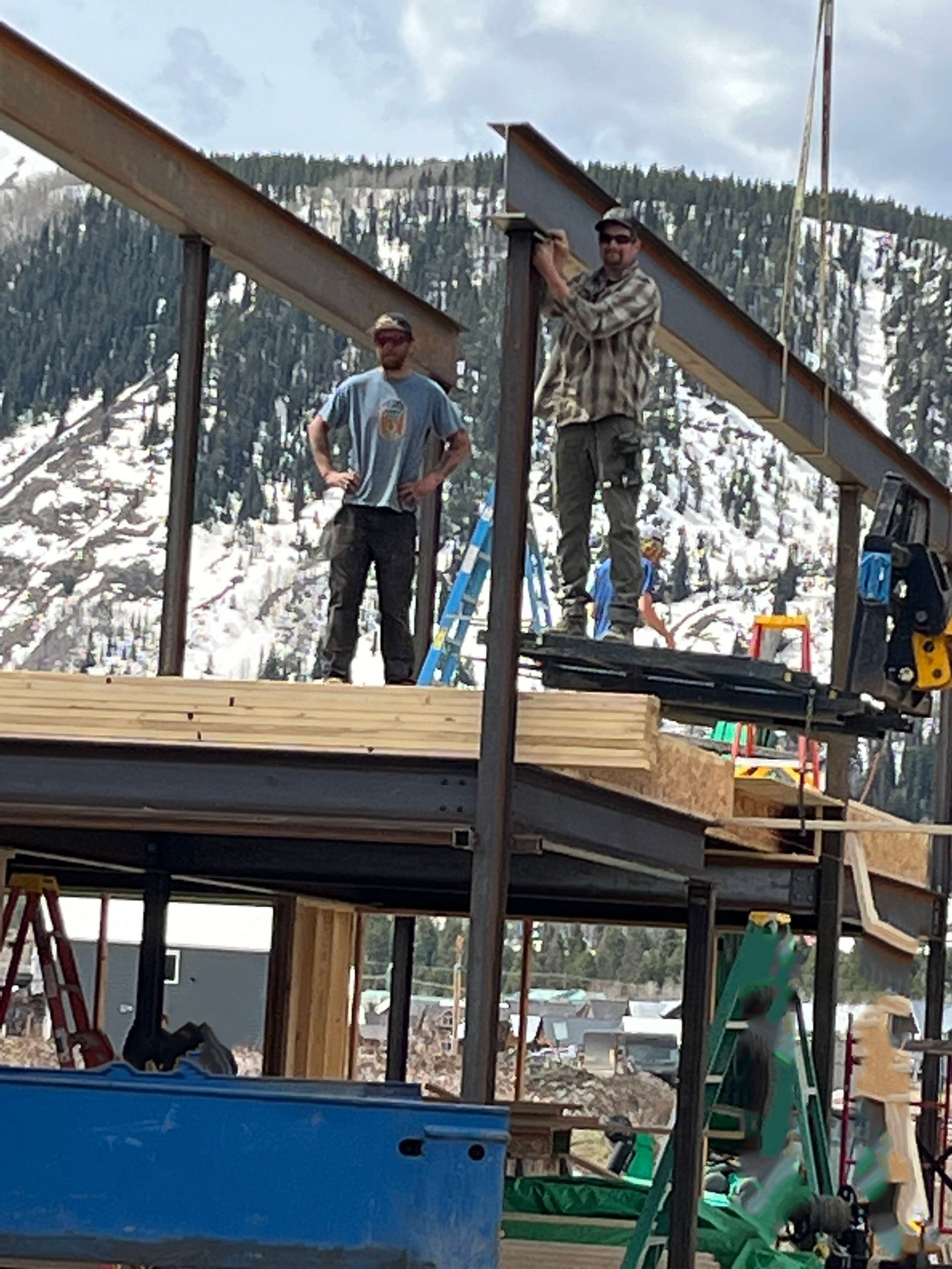 A couple of men standing on top of a metal structure