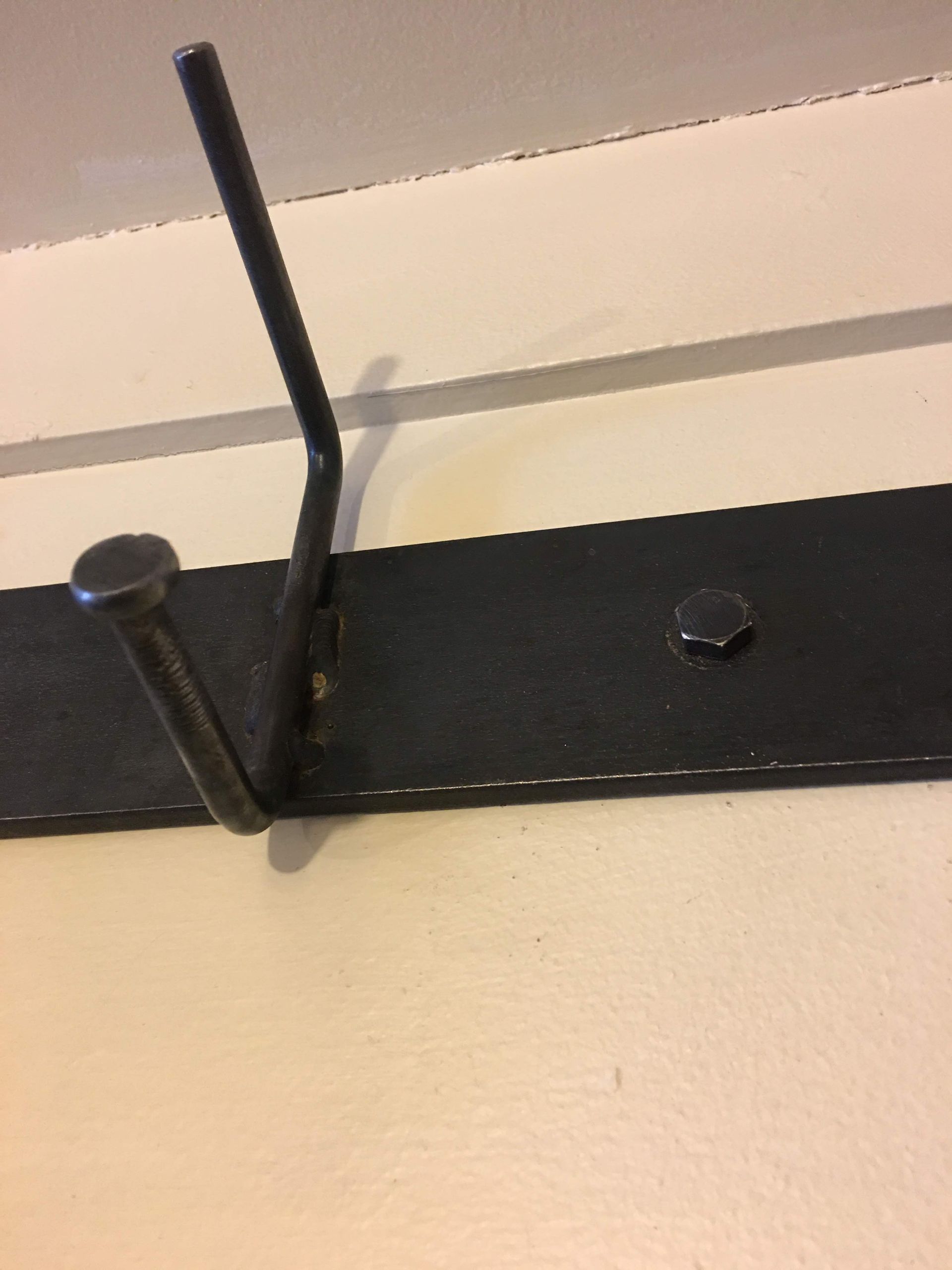 A close up of a metal hook on a wall