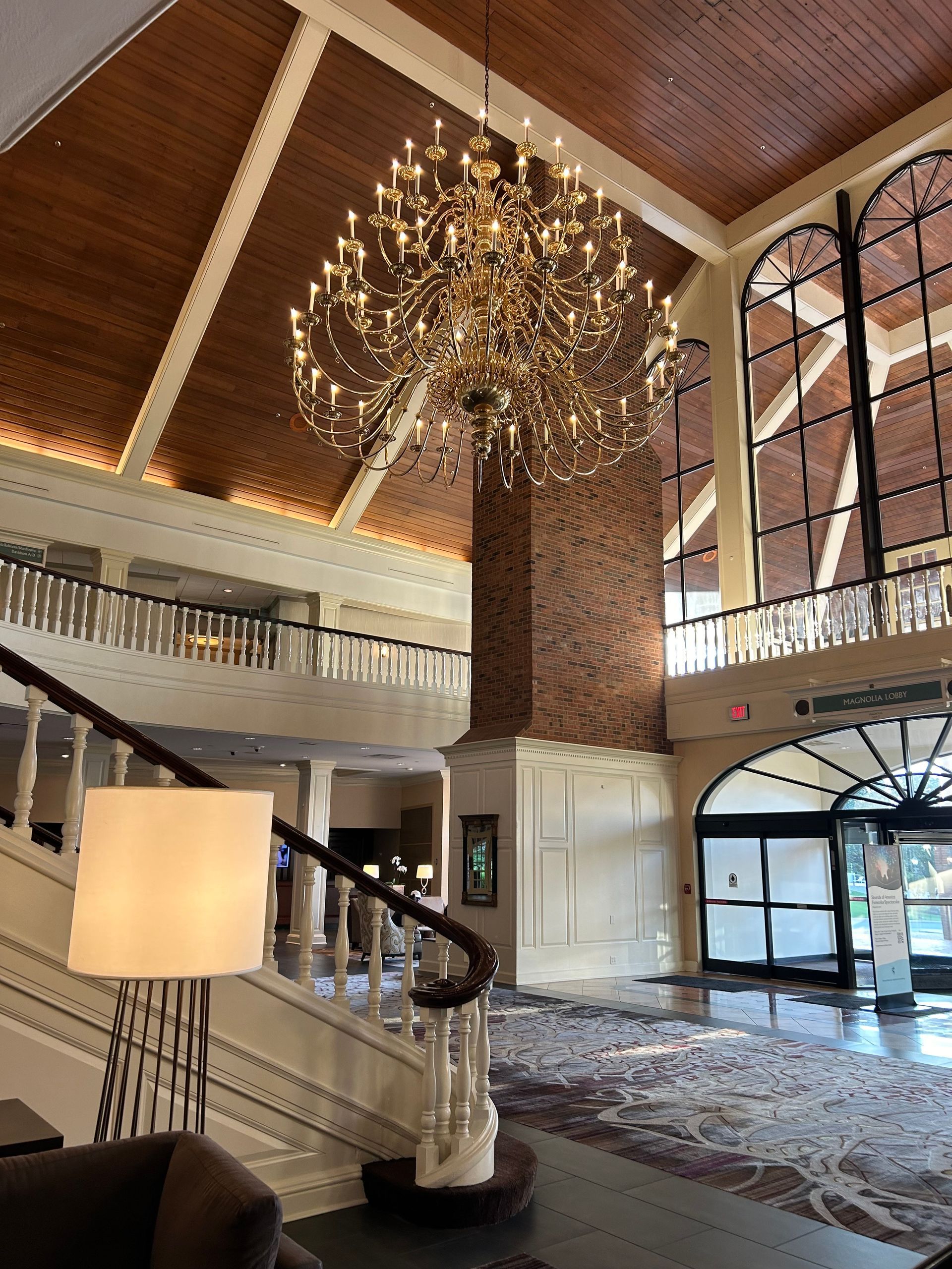 Grand hotel lobby with large chandelier and accent lighting installed by commercial lighting specialists.