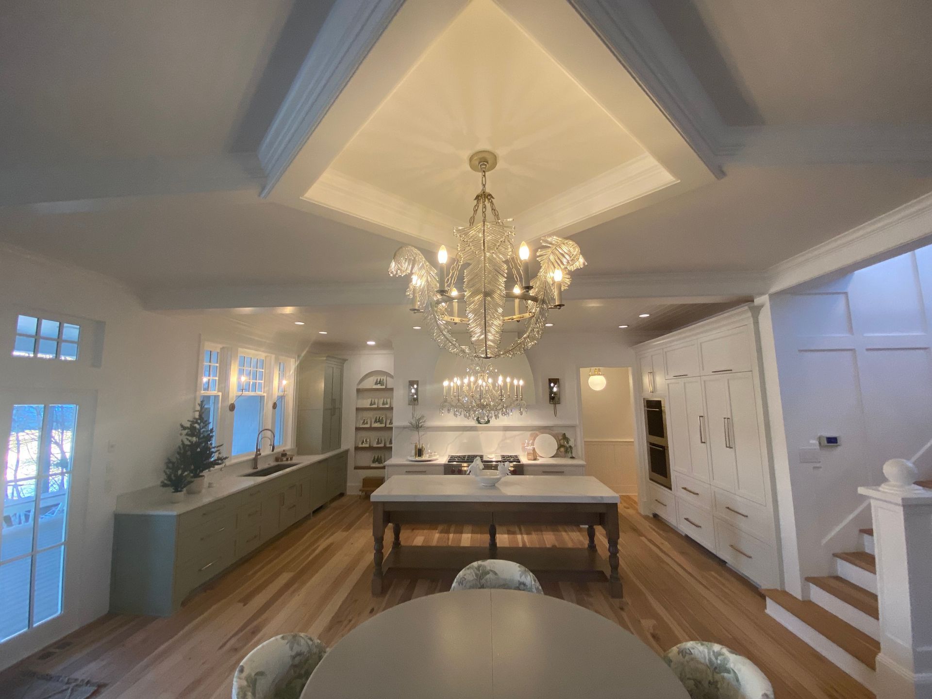 Spacious kitchen with custom chandelier and recessed lighting installed by licensed residential electricians.