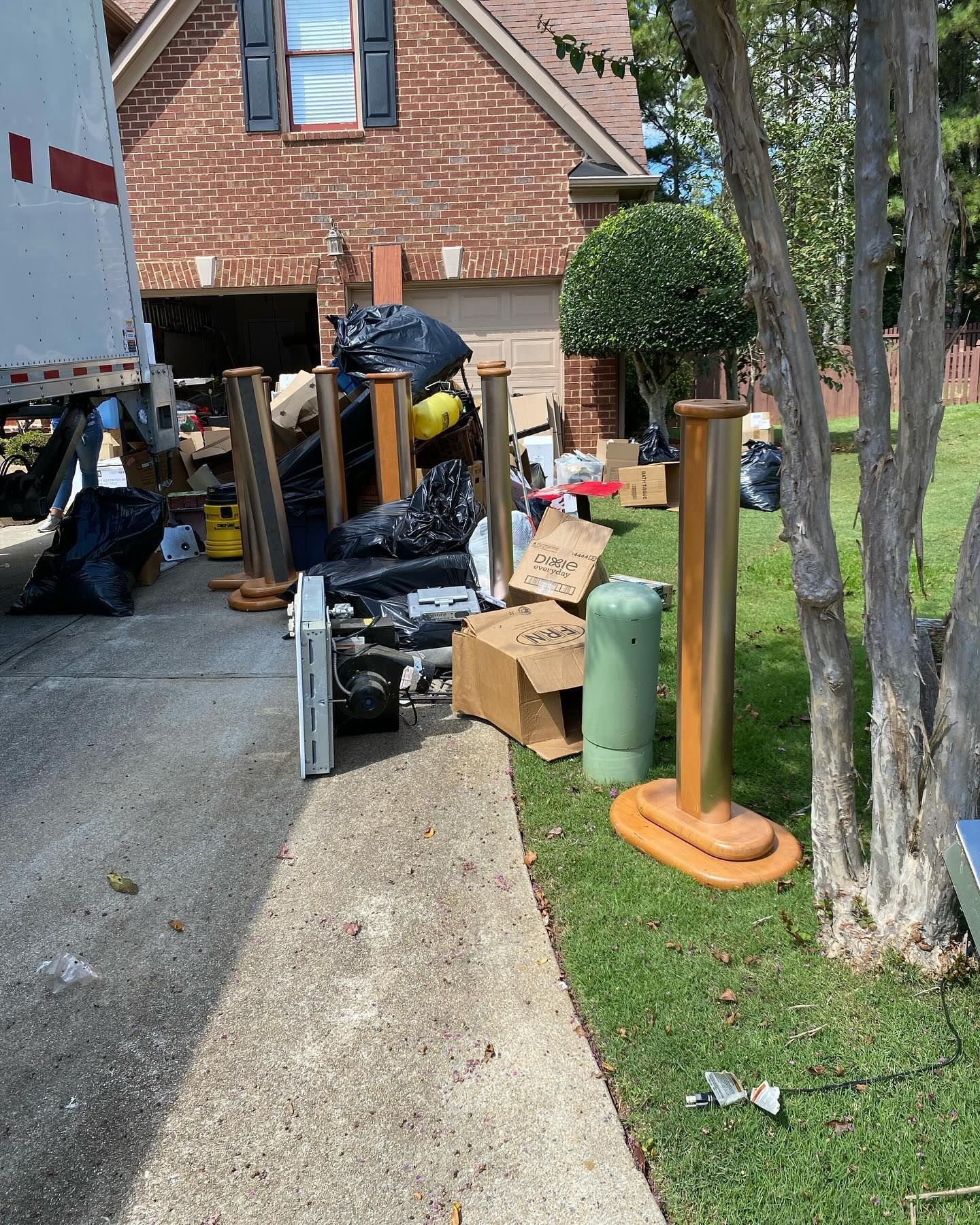 A pile of garbage is sitting in front of a brick house.