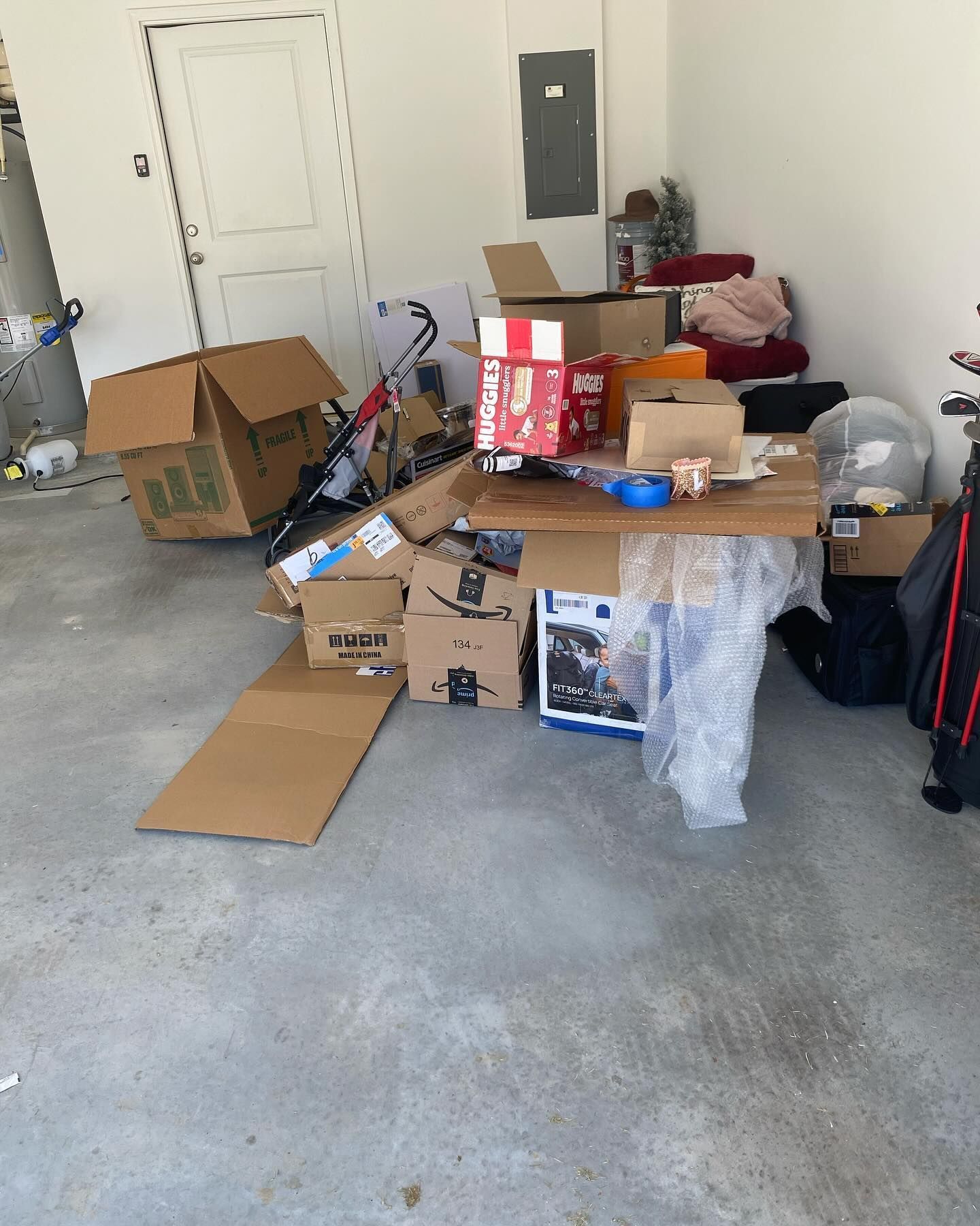 A garage filled with lots of cardboard boxes and other items.