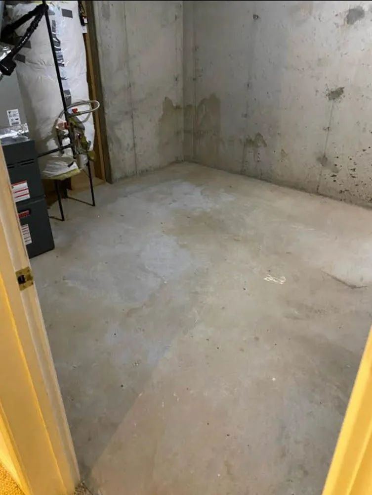 A room with a concrete floor and a concrete wall.