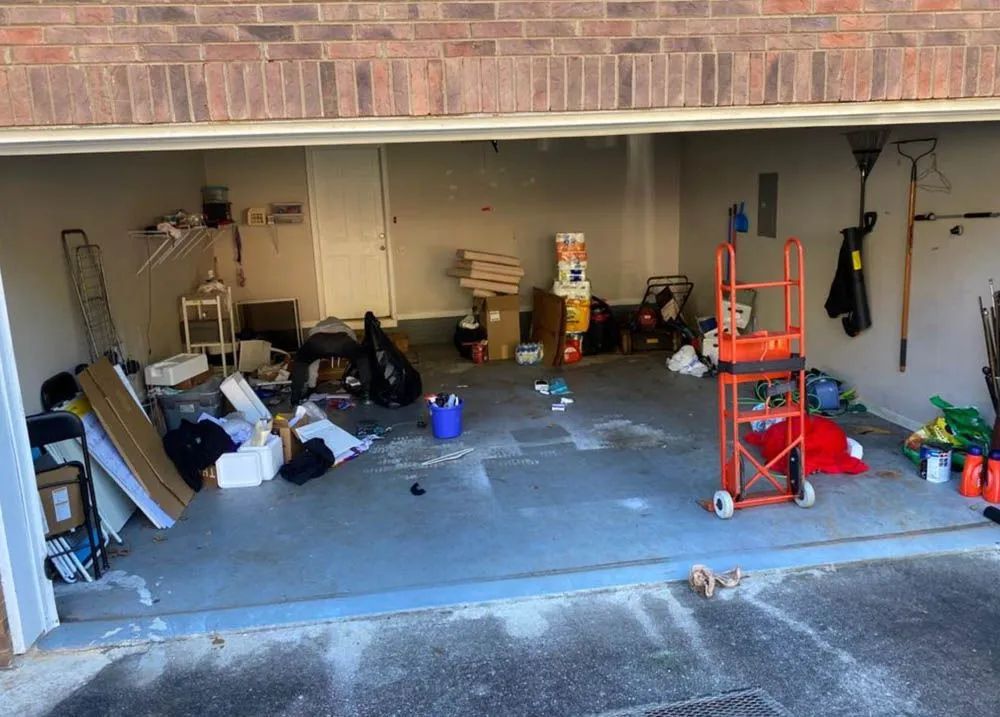 A garage filled with lots of junk and a ladder.