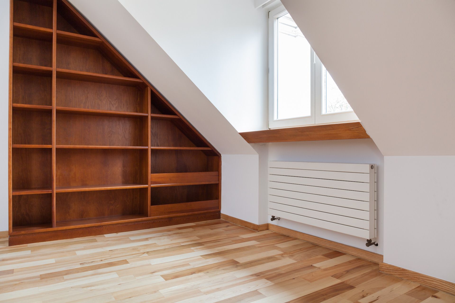 An empty room with wooden shelves and a radiator.