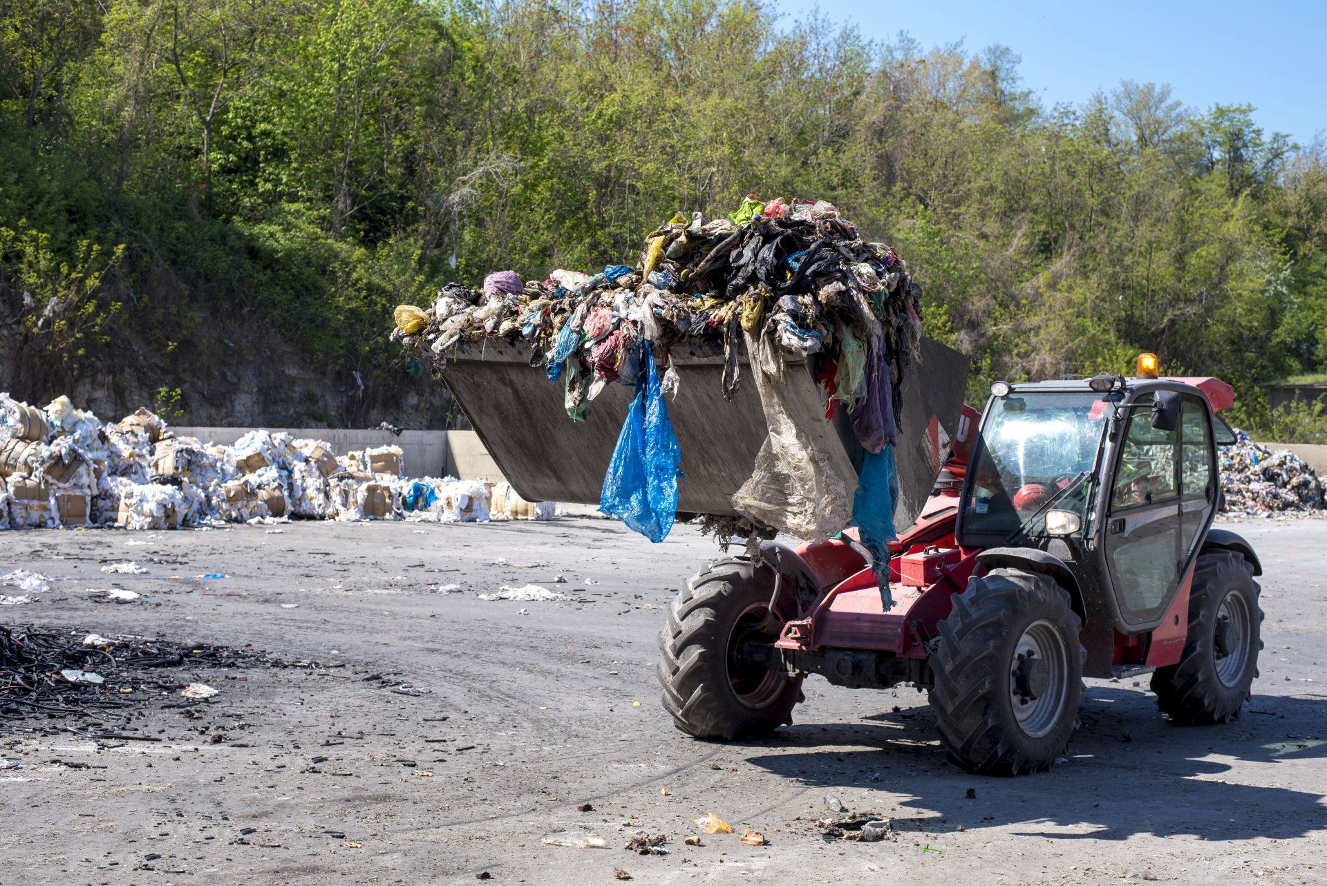 Cargadora de ruedas que transporta residuos municipales a la planta de tratamiento de residuos