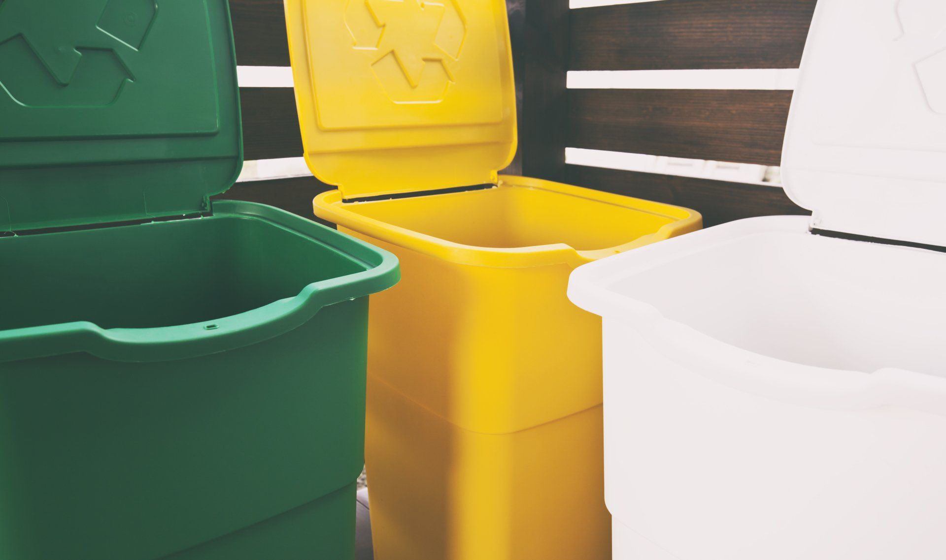 Tres botes de basura de colores para clasificar la basura para vidrio y papel de plástico