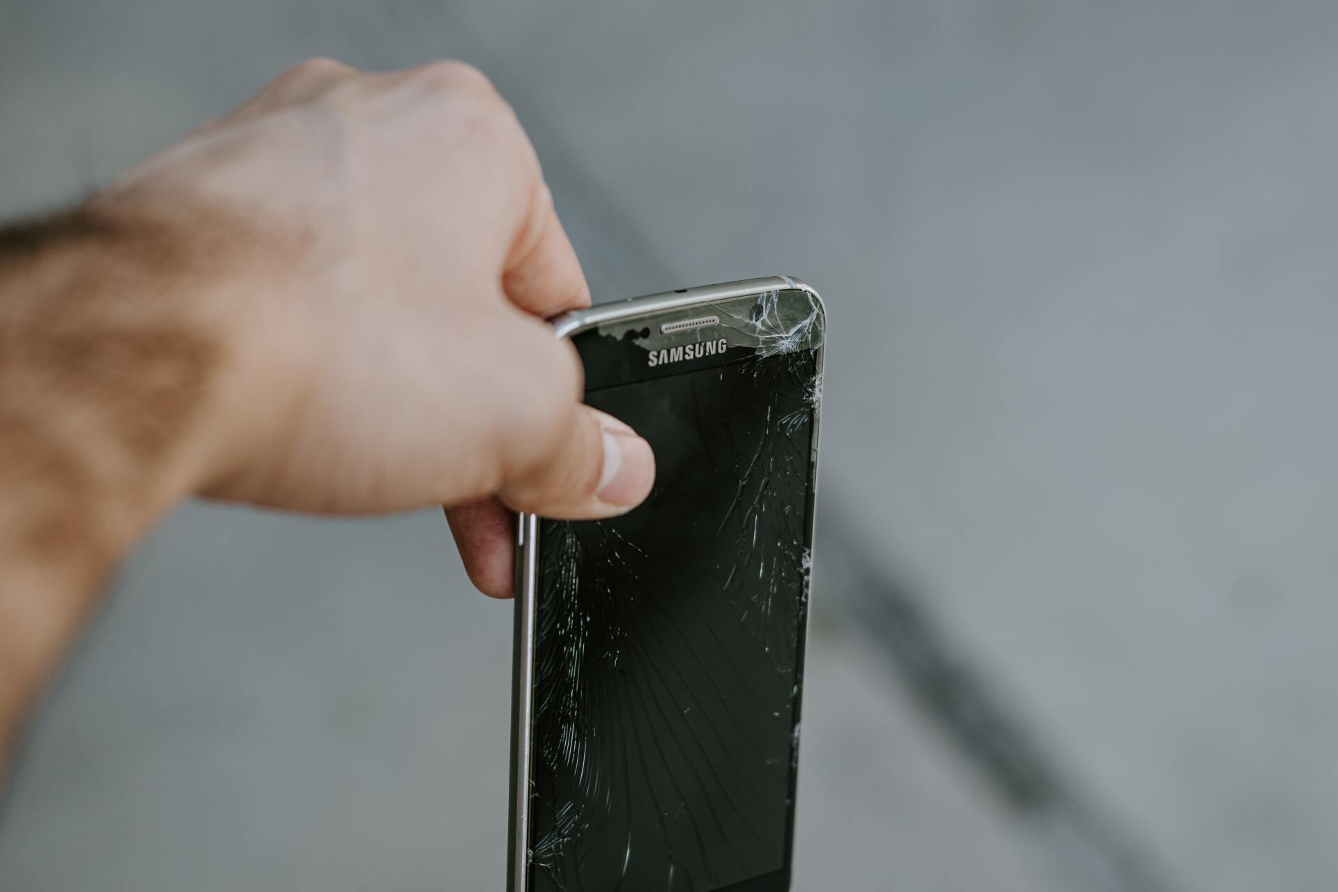 celular roto siendo tirado a la basura