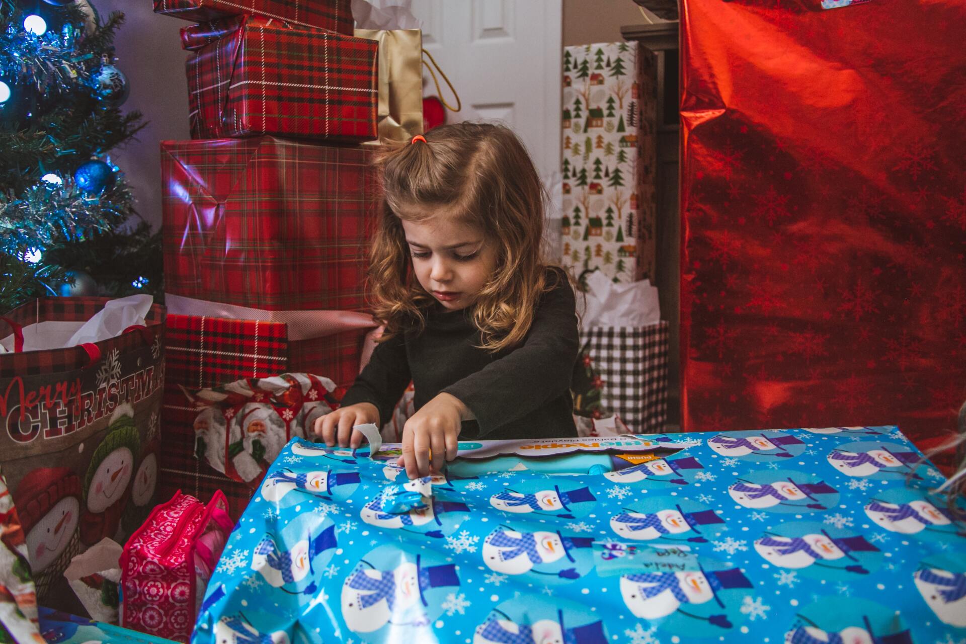 niña abriendo con cuidado su regalos para limitar la generación de basura
