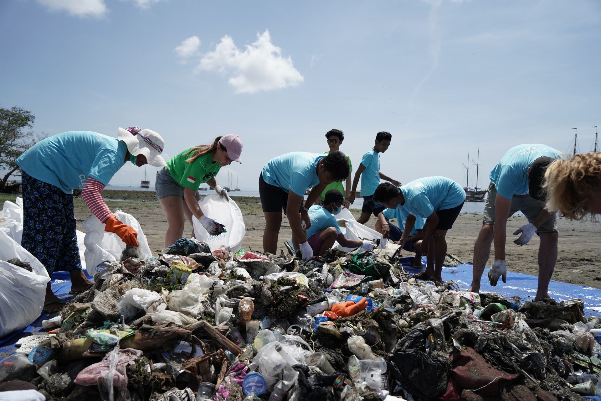 grupo de hombres y mujeres promoviendo la responsabilidad sobre gestión de residuos en la playa