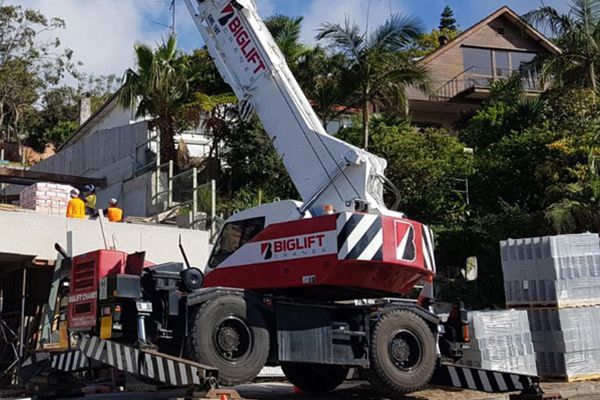 A red and white crane is parked in front of a house.