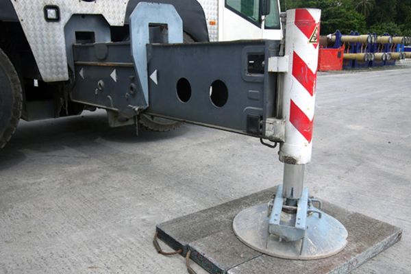 A truck with a crane attached to it is parked in a parking lot