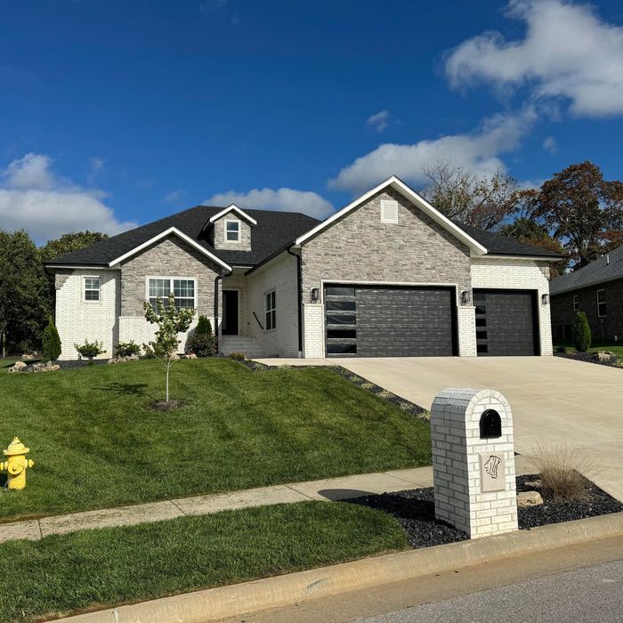 A house with a beautiful lawn and mailbox in front of it