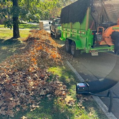A green trailer with a blower attached to it