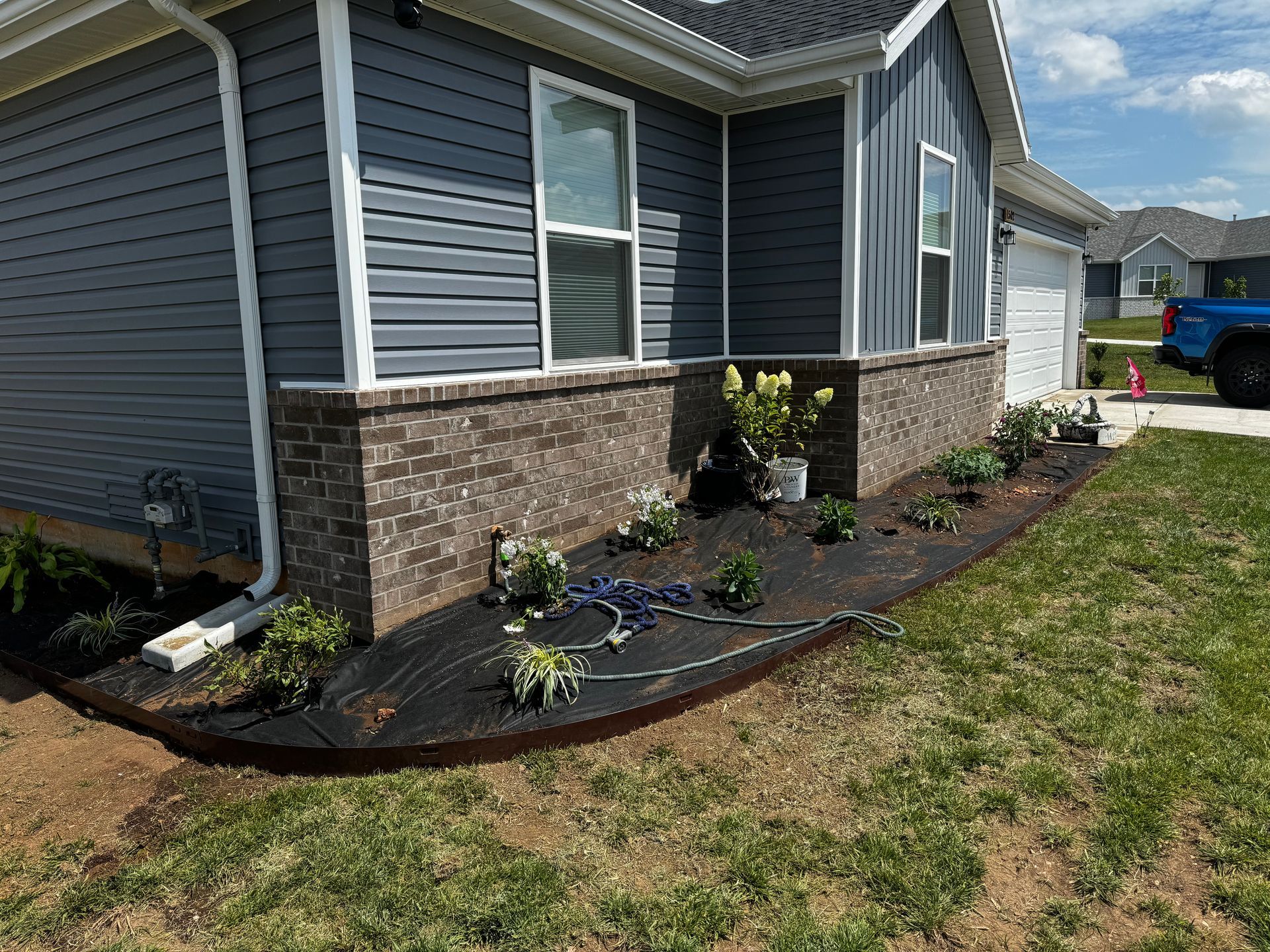 A blue truck is parked in front of a house.