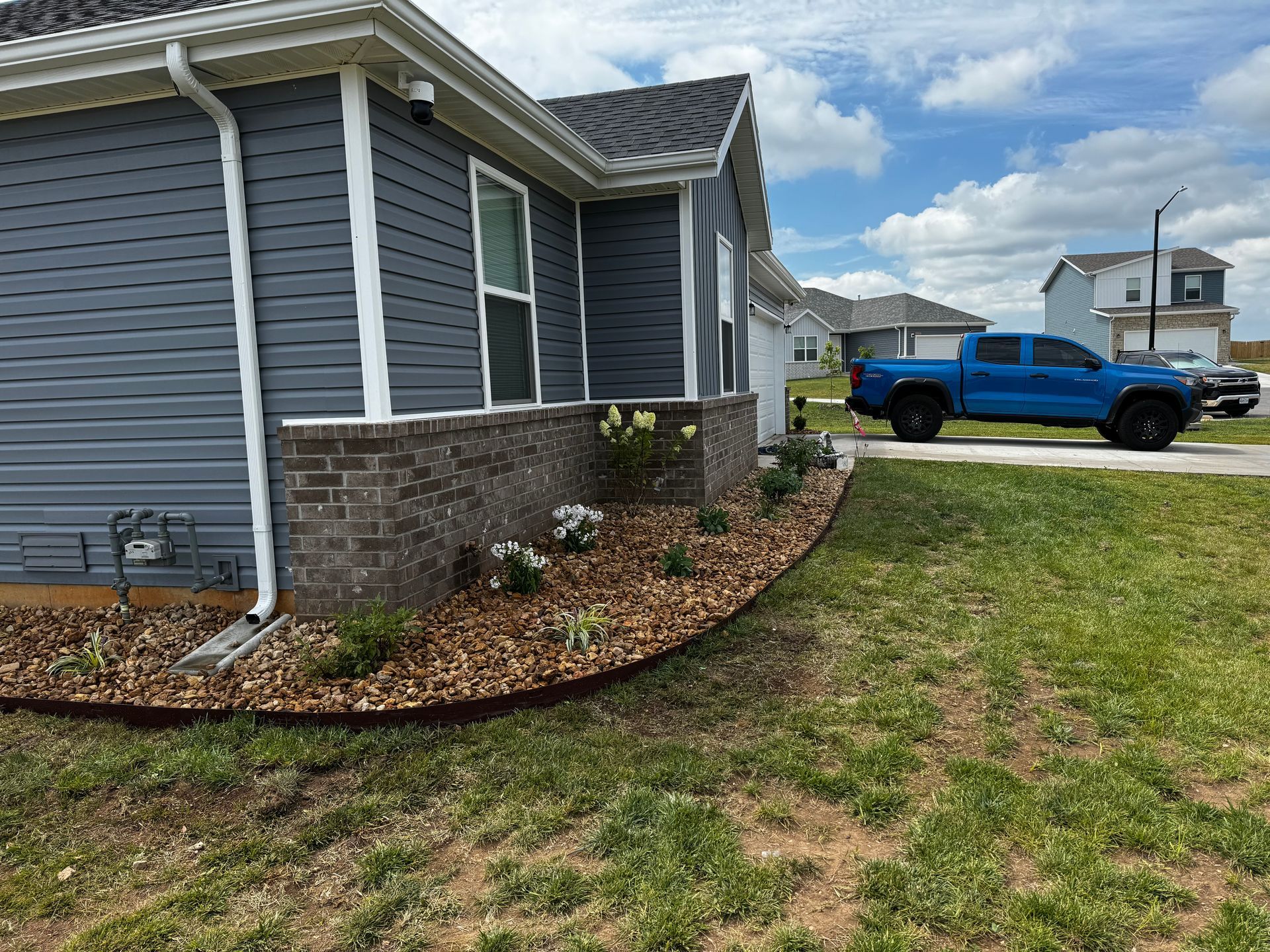 A blue truck is parked in front of a house