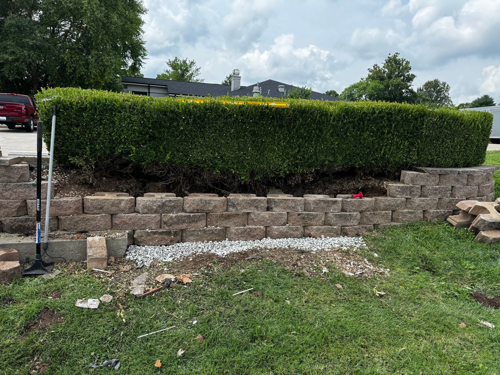 A brick wall is being built in front of a house