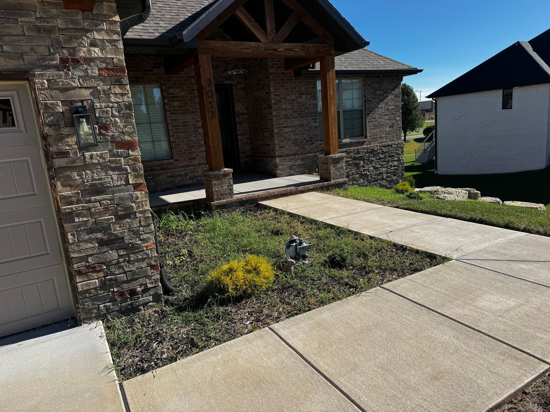 A brick house with a concrete walkway leading to it