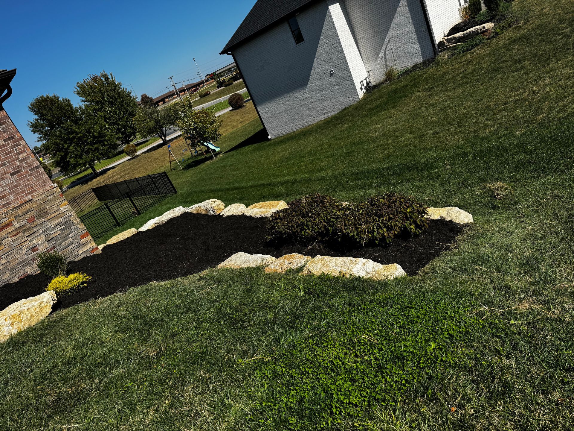 A lush green lawn with a white building in the background