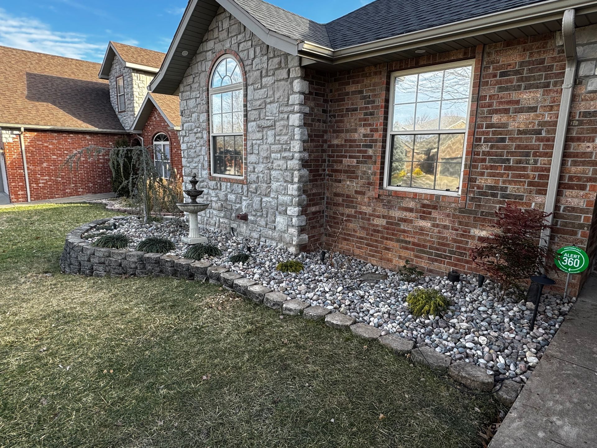 A brick house with a garden in front of it