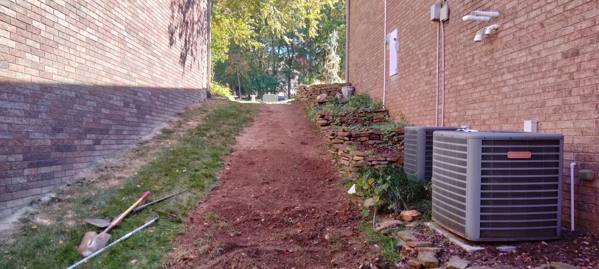 Two air conditioners are sitting on the side of a building
