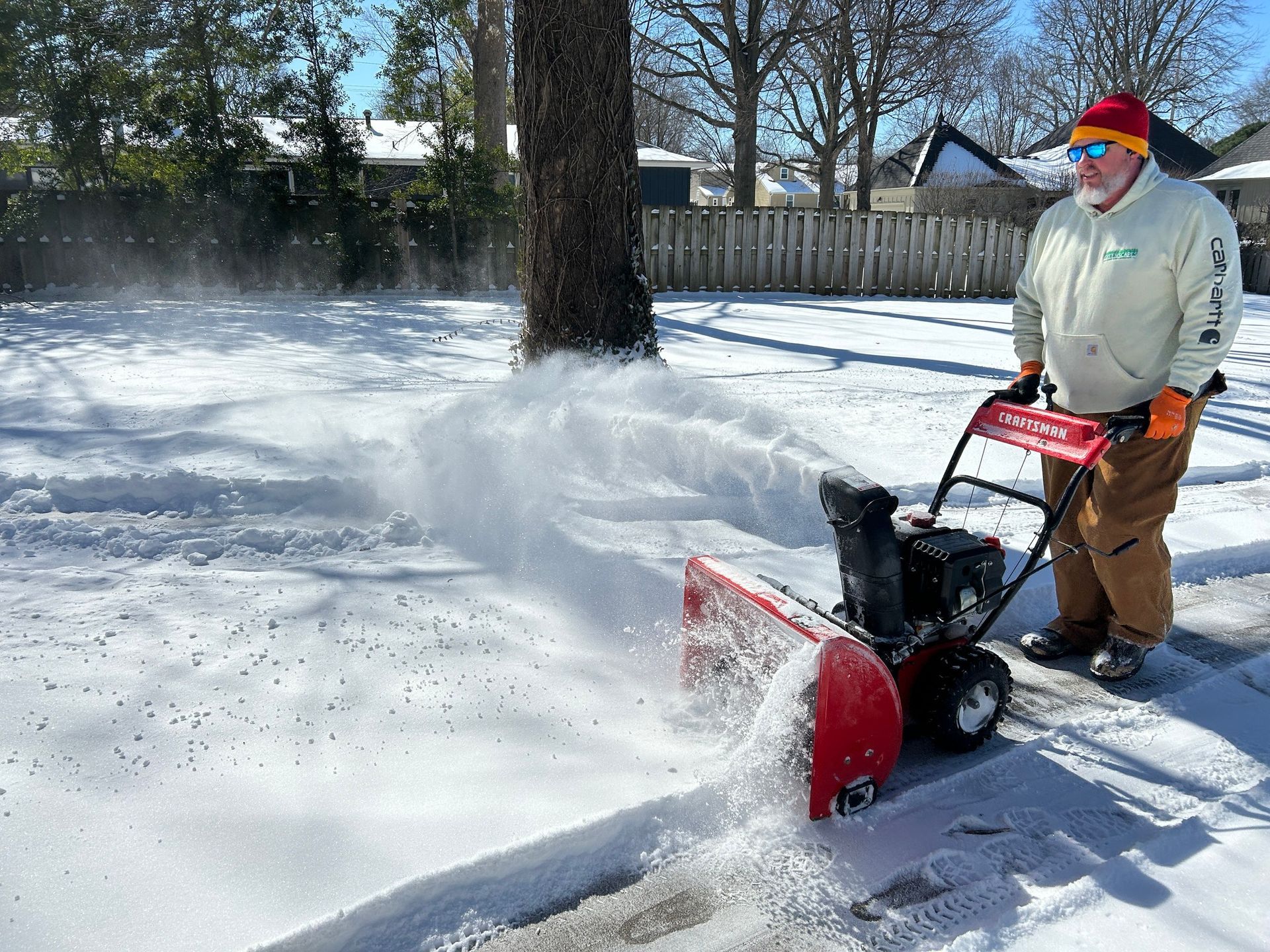 A man is using a snow blower to clear snow