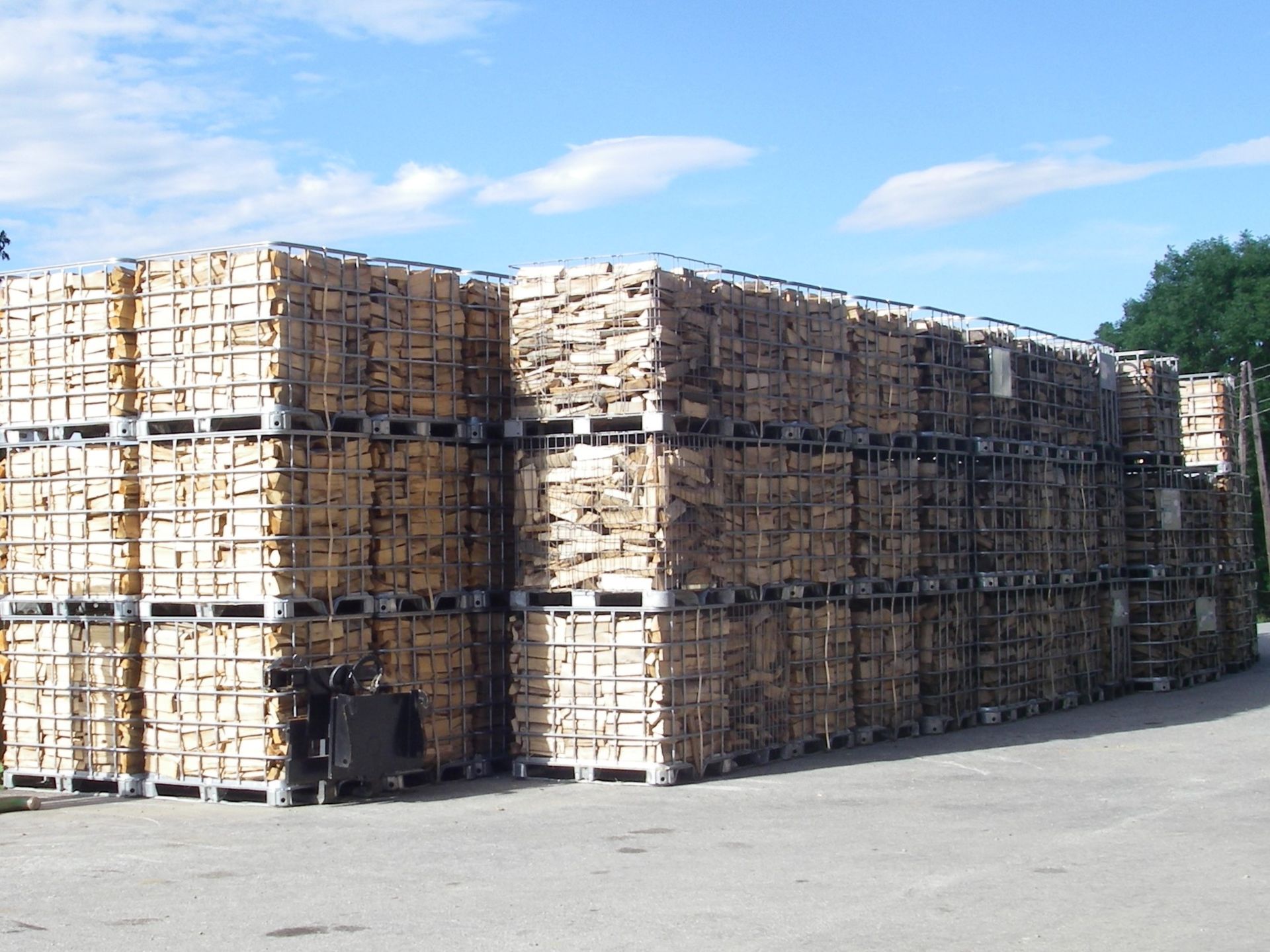 Im Freien unter blauem Himmel waren ordentlich auf Paletten gestapelte Brennholzstücke zu sehen.