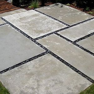 Stone patio pavers with dark gravel joints in a landscaped outdoor area