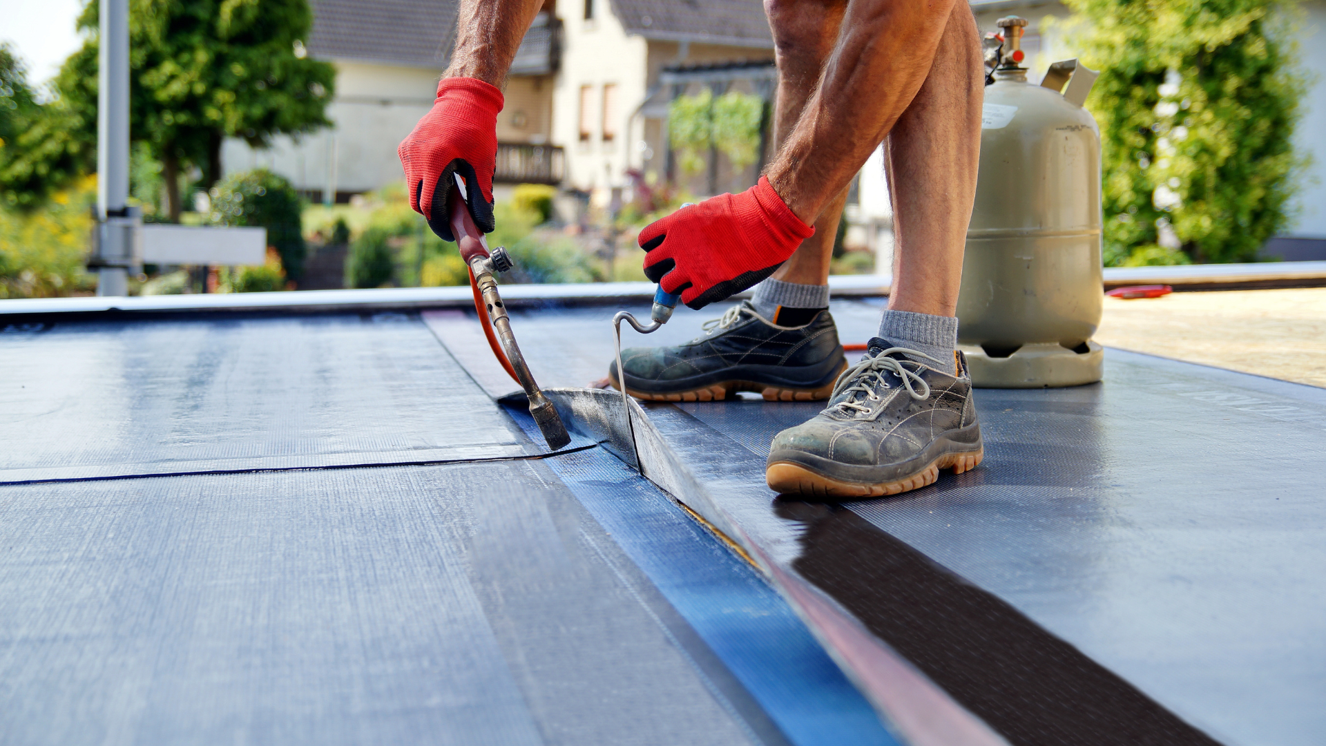 A man is applying a roof coating to a roof.