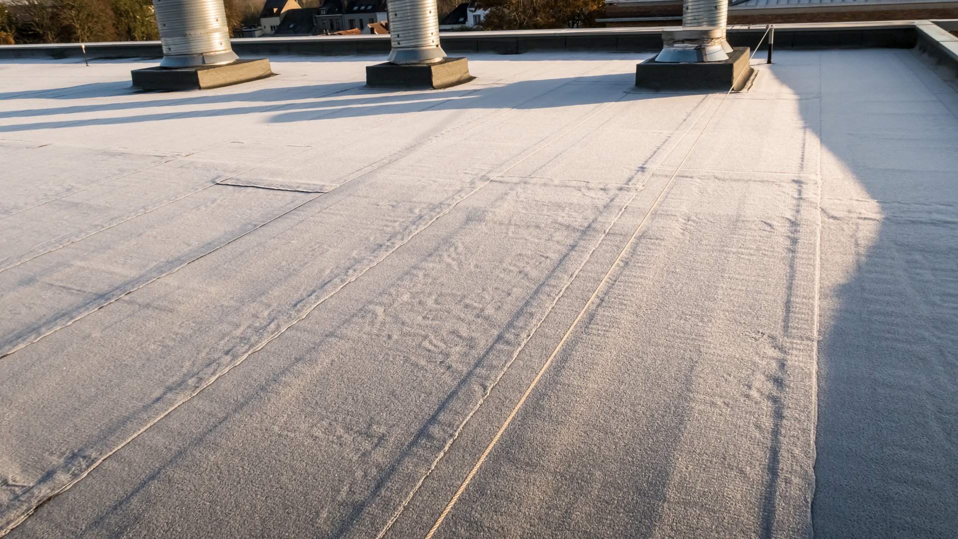 A close up of a roof with a few chimneys on it.